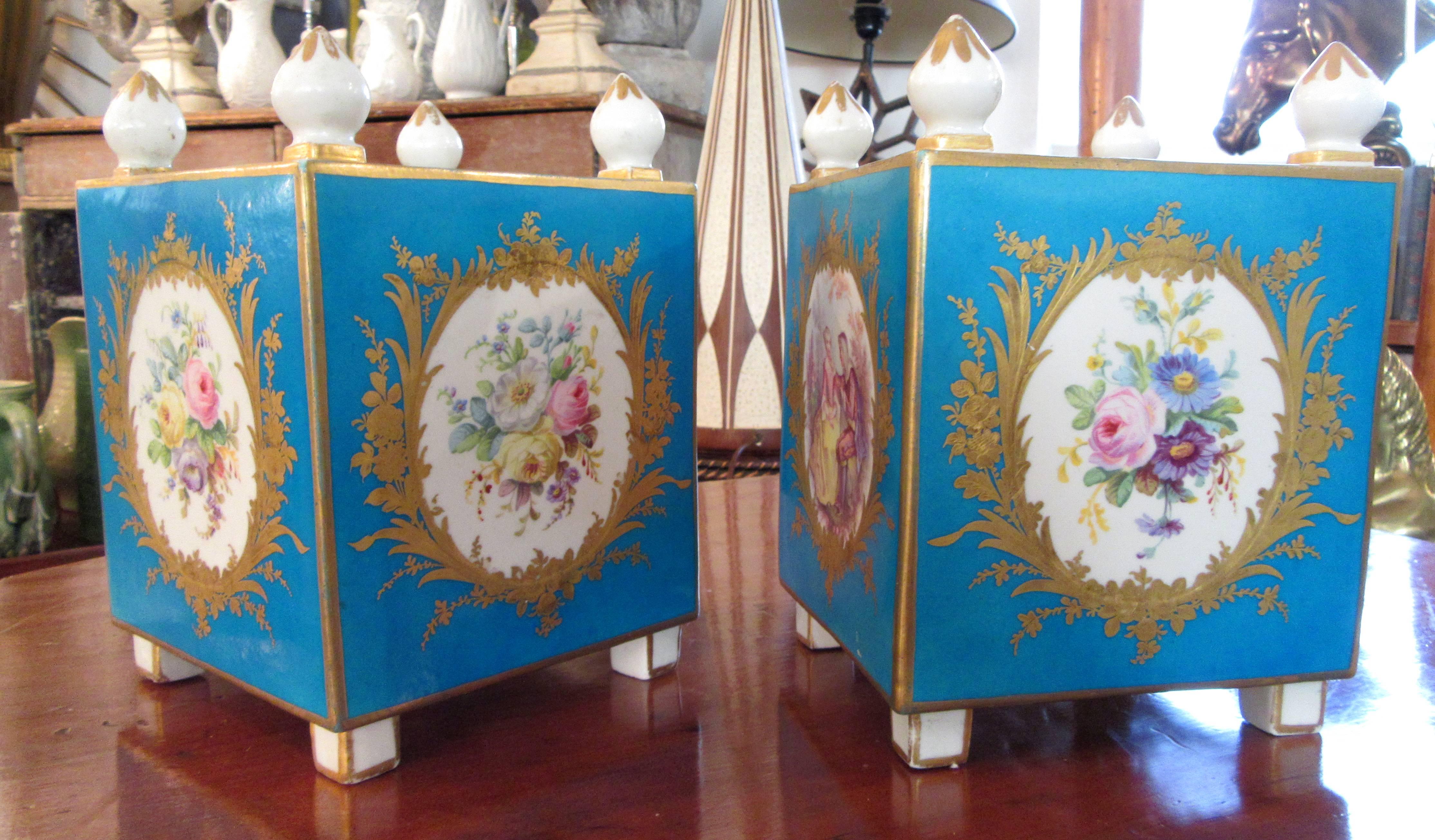 A pair of early Sevres (Vincennes) porcelain orange pots with the traditional blue turquoise background. Three sides are medallions of flowers while the Fourth is a romantic scene. All are surrounded by gilt foliage.