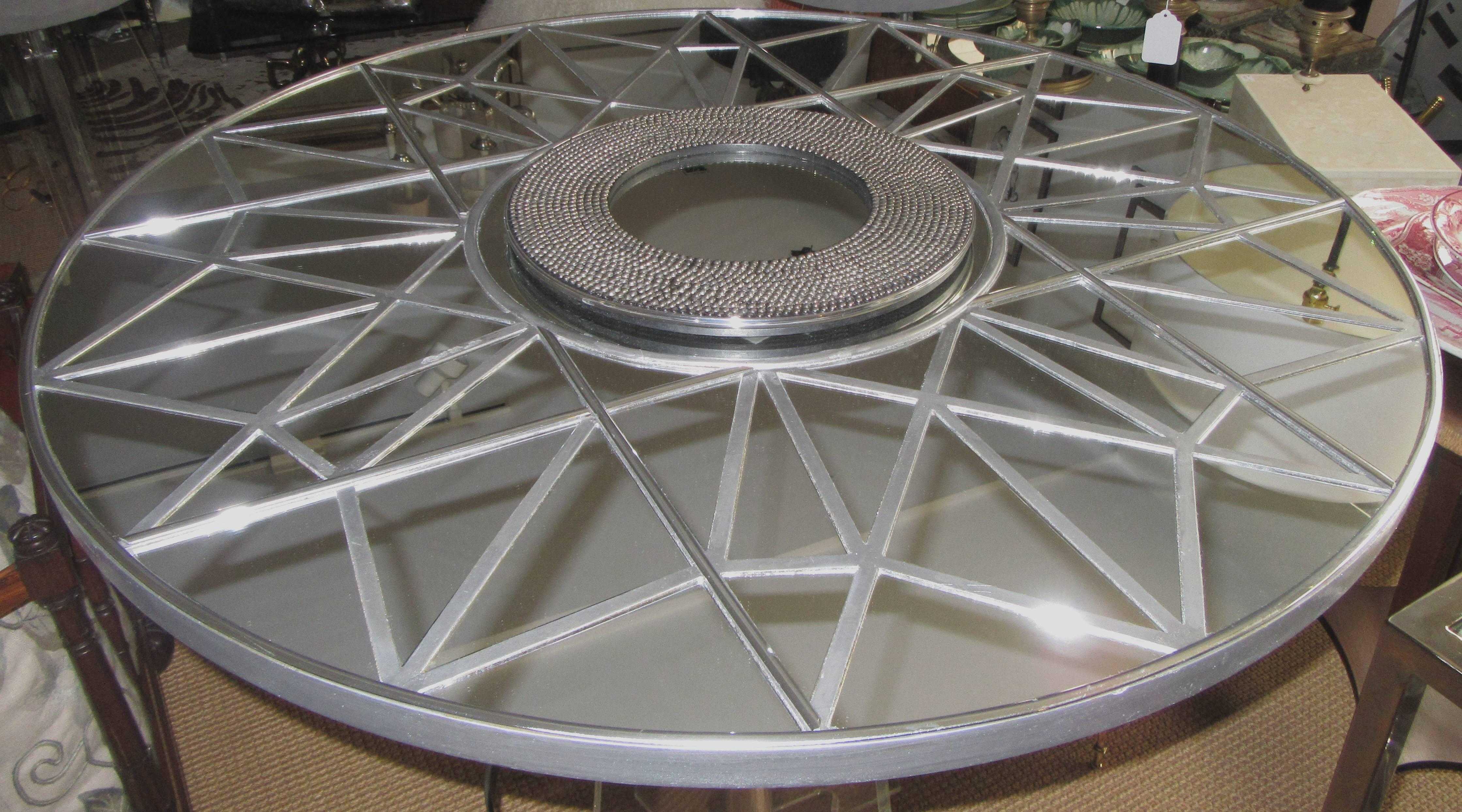 A large round mirror divided into geometric segments. The center is a circle of metal studs.
