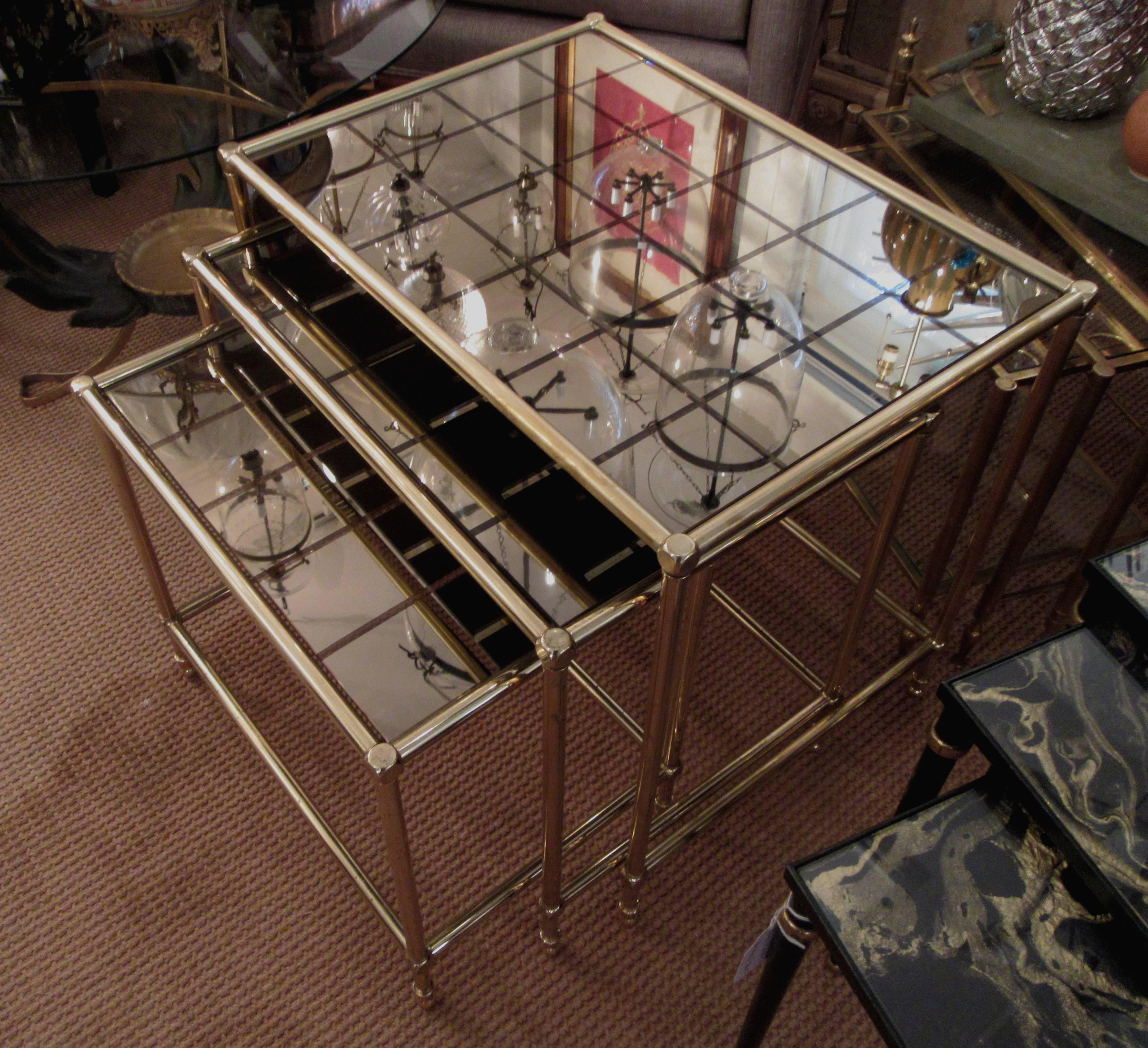 A set of three tubular brass nesting tables, inset with original grid design glass.
Mirrored squares are divided by smokey amber glass.