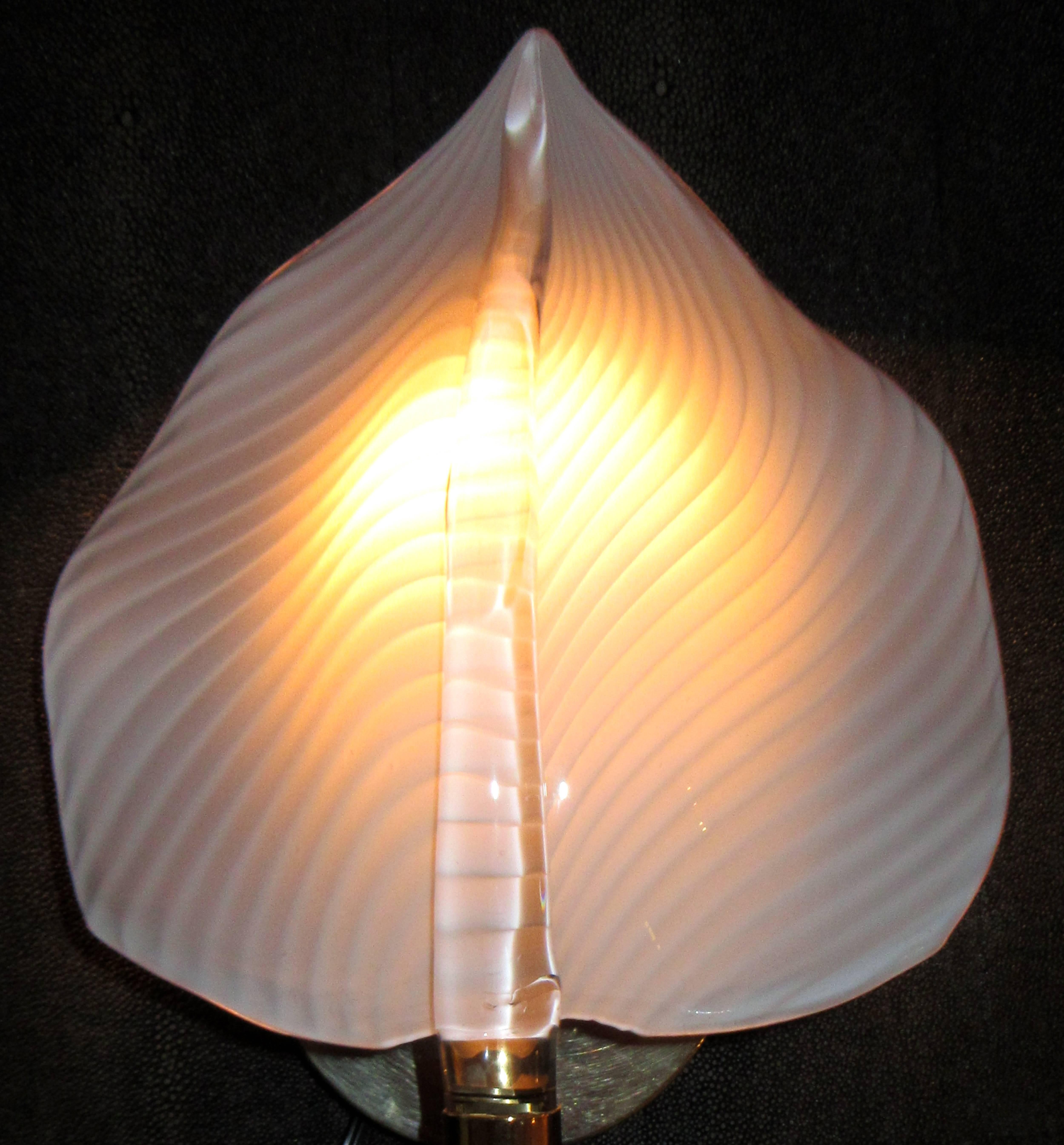A pair 'two pairs available' of handblown Italian glass wall sconces in the form of leaves with a stem. The leaf shaped shade is a striated white and the 