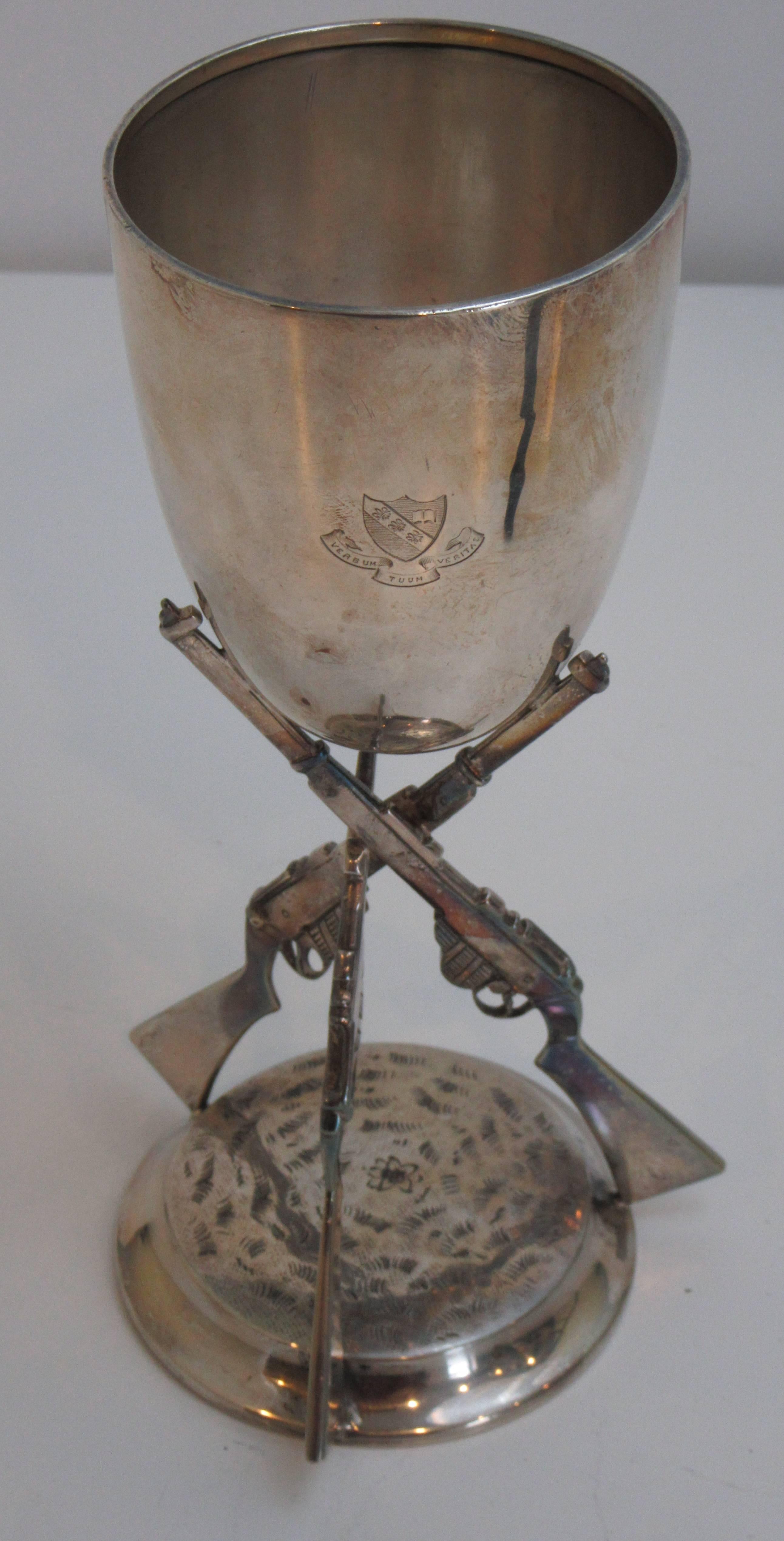 A sterling silver chalice produced by William Hutton & Sons. The cup is marked with the motto and crest of the Monkton Combe School in Bath, England.
Verbum Tuum Veritas (Thy Word is Truth).
The stem is formed by three standing rifles.