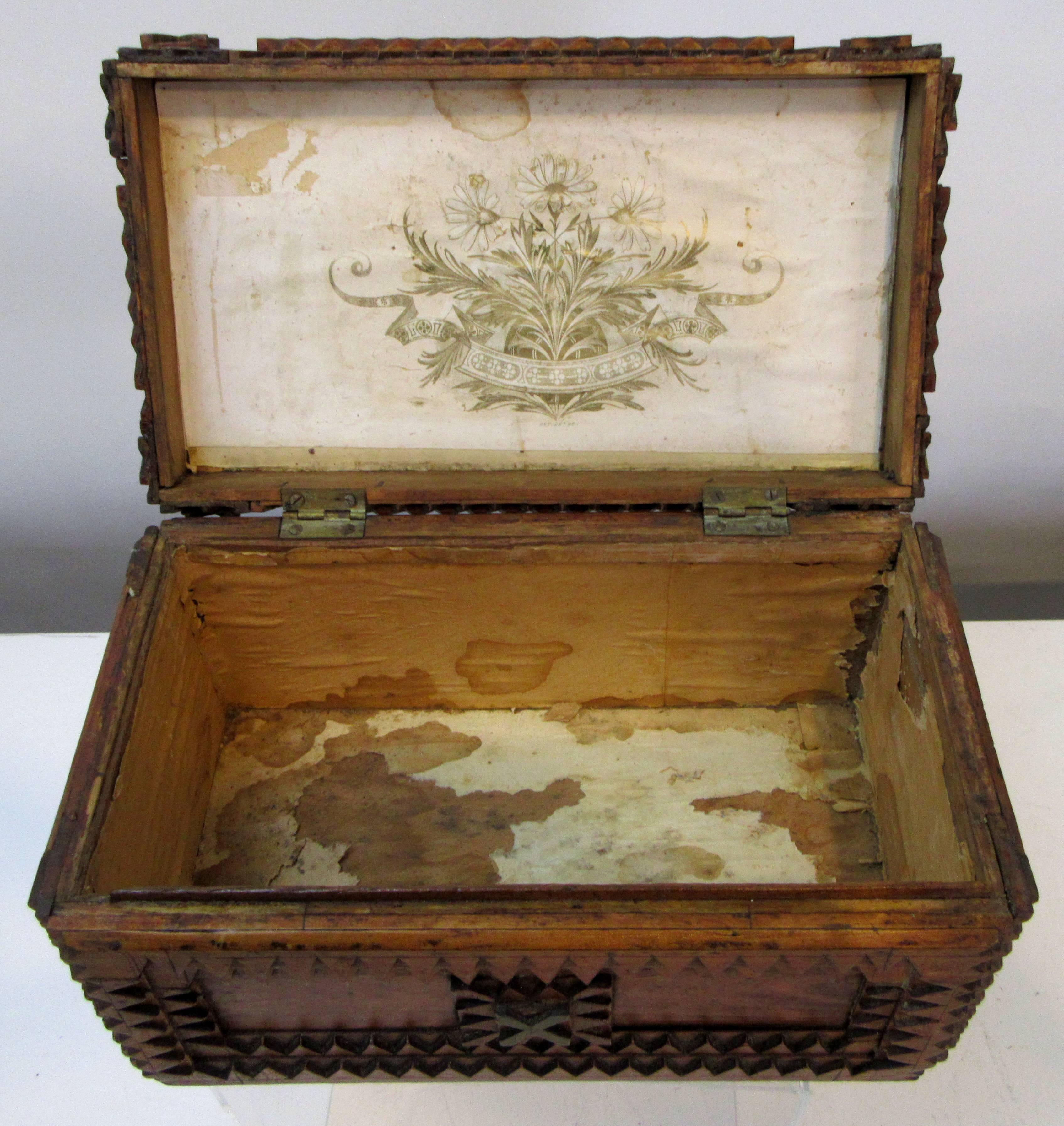 A hinged lid Tramp Art box made using a Schutz Marke Deponirt Razor Box from Germany. The inside of the lid is lined with a gold flower and banner pattern.