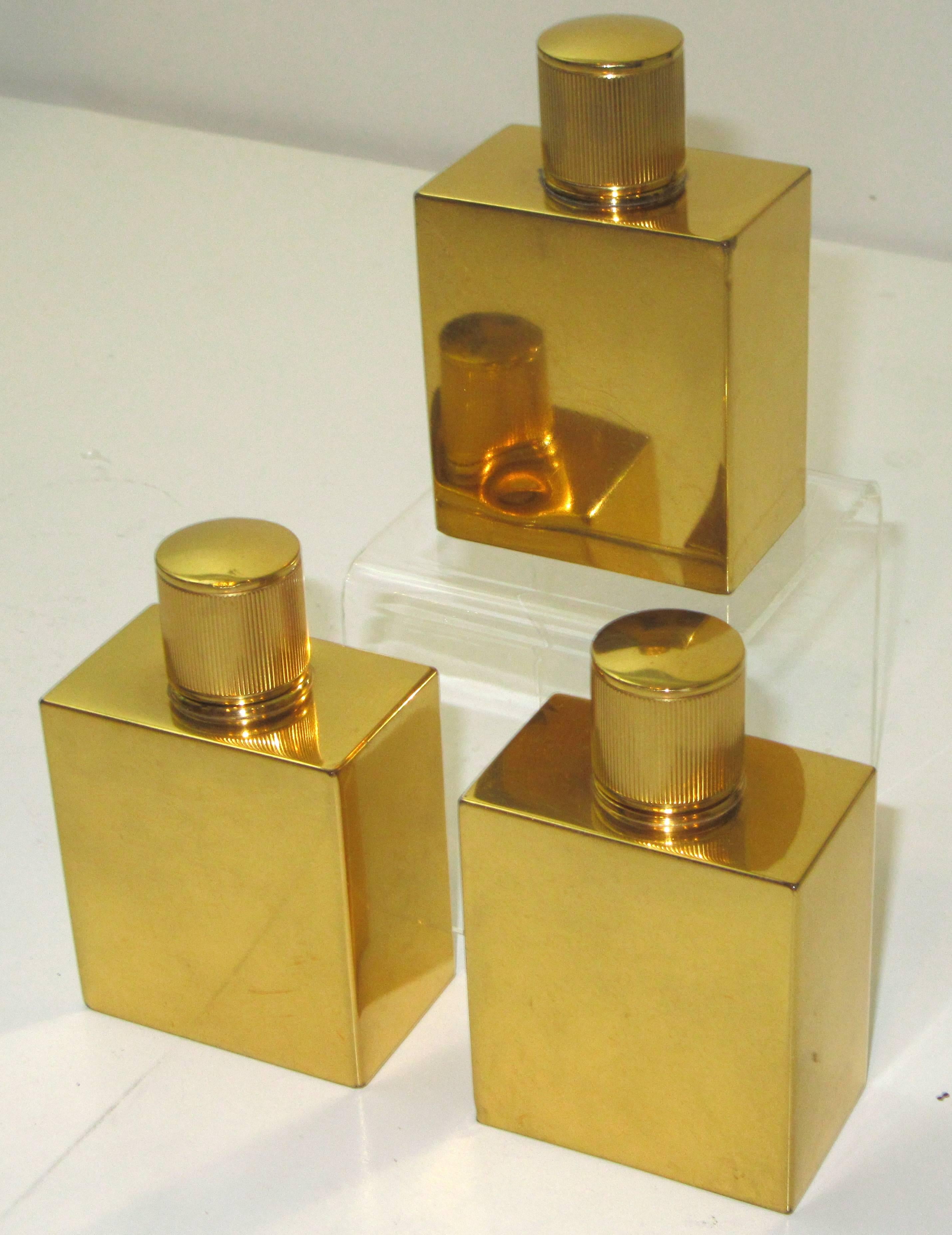 Three identical gold plated rectangular form bottles stamped HERMES, Paris.