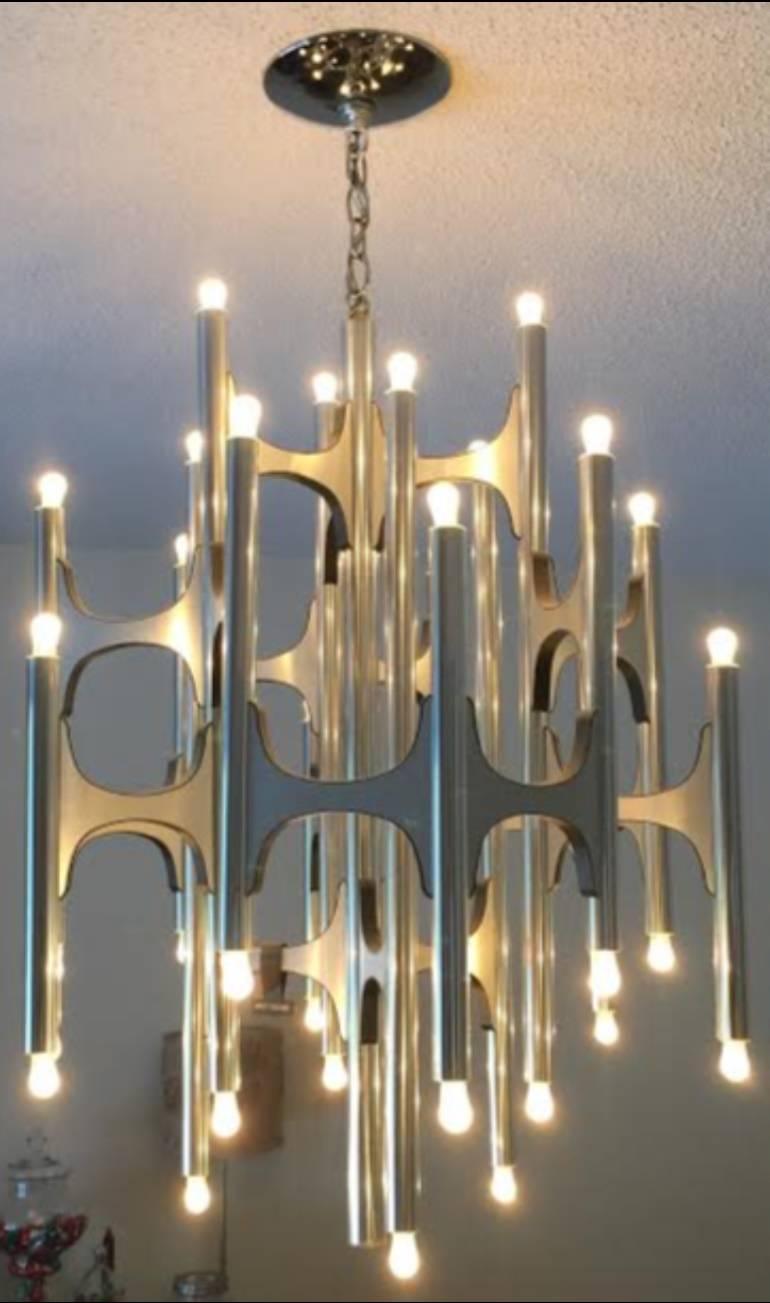 A pair of thirty-six-light aluminum modernist chandeliers designed by Gaetano Sciolari, and manufactured by Lightolier. The original Lightolier tag remains hanging from one of the chandeliers.