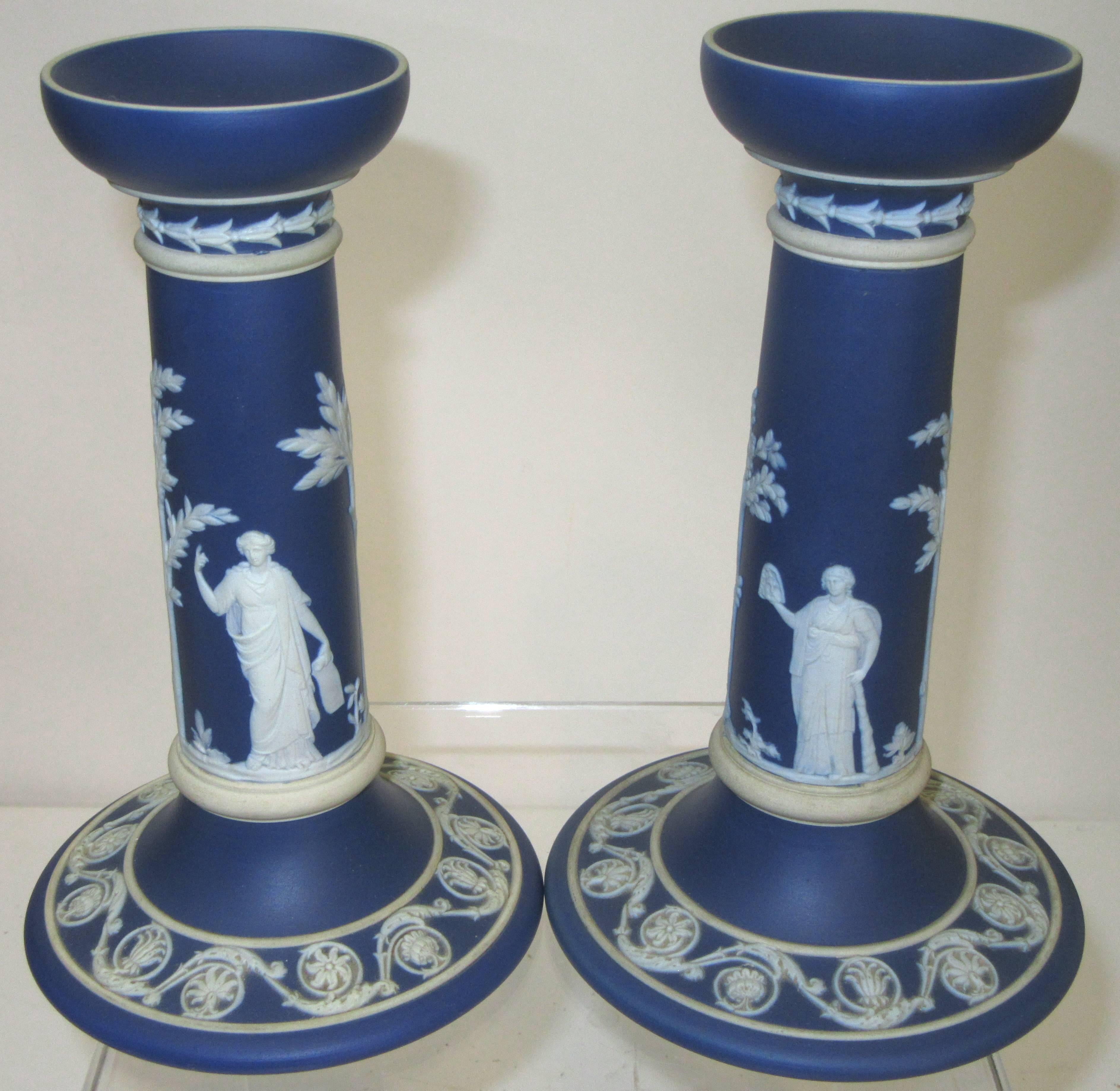 A complimentary pair of dark blue and white, neoclassic design jasperware candleholders. Stamped Wedgwood.