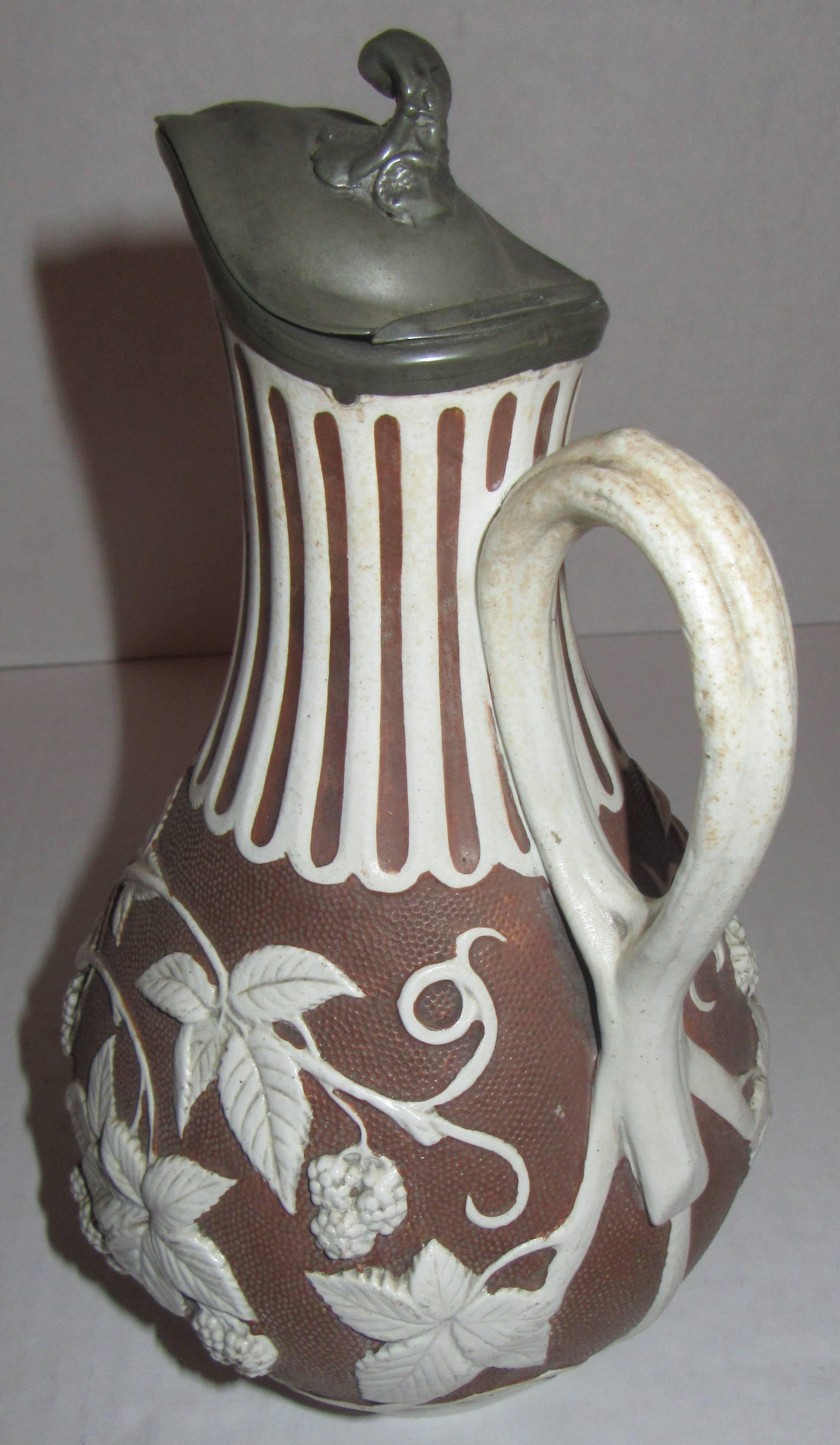 Blackberry on the vine, brown and white Parian ware pitcher with the original pewter lid. The marking dates it to being produced in England on January 18th, 1863.