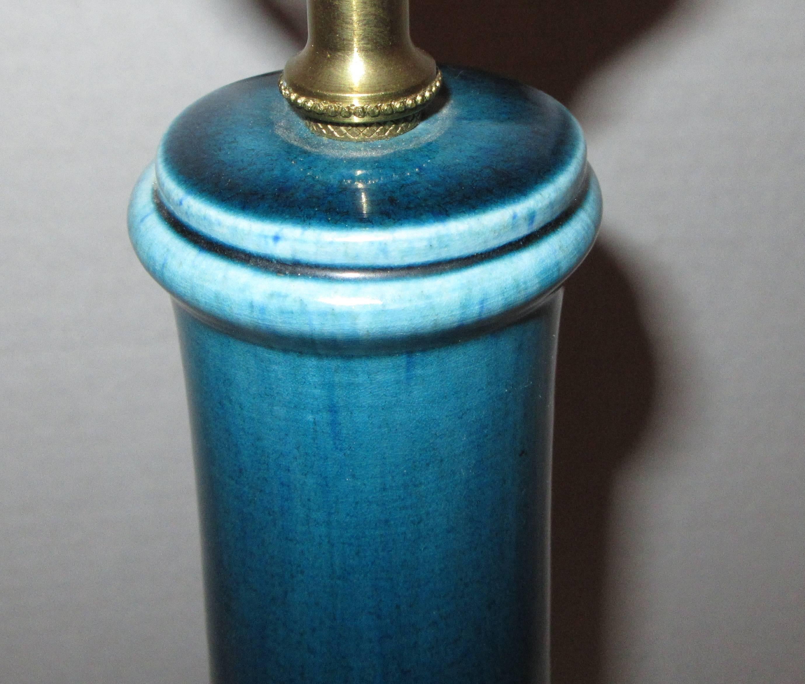 A bottle form ceramic table lamp glazed in a rich blue.