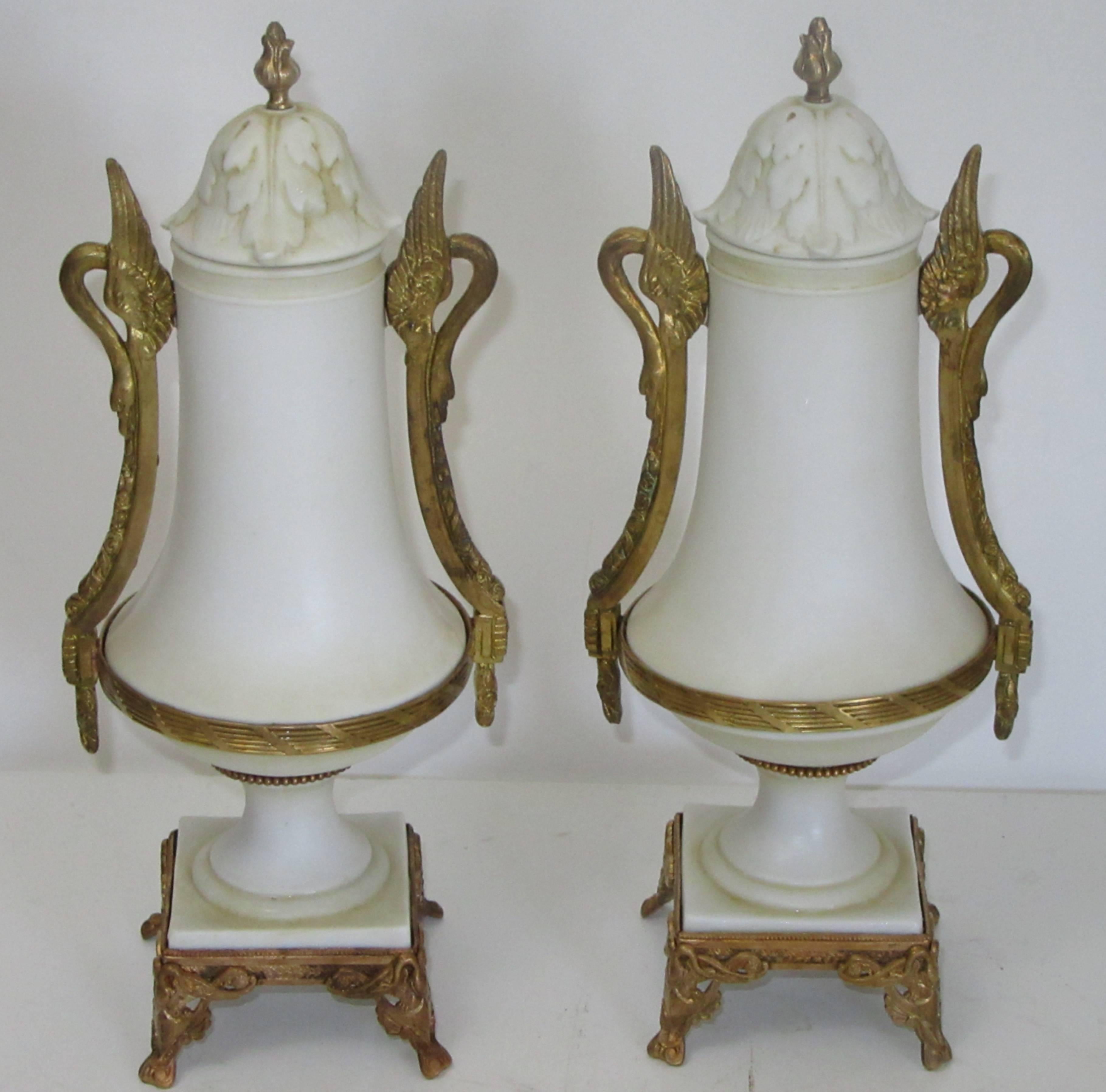 A pair of bisque porcelain lidded urns mounted with bronze doré by A&E Muller.