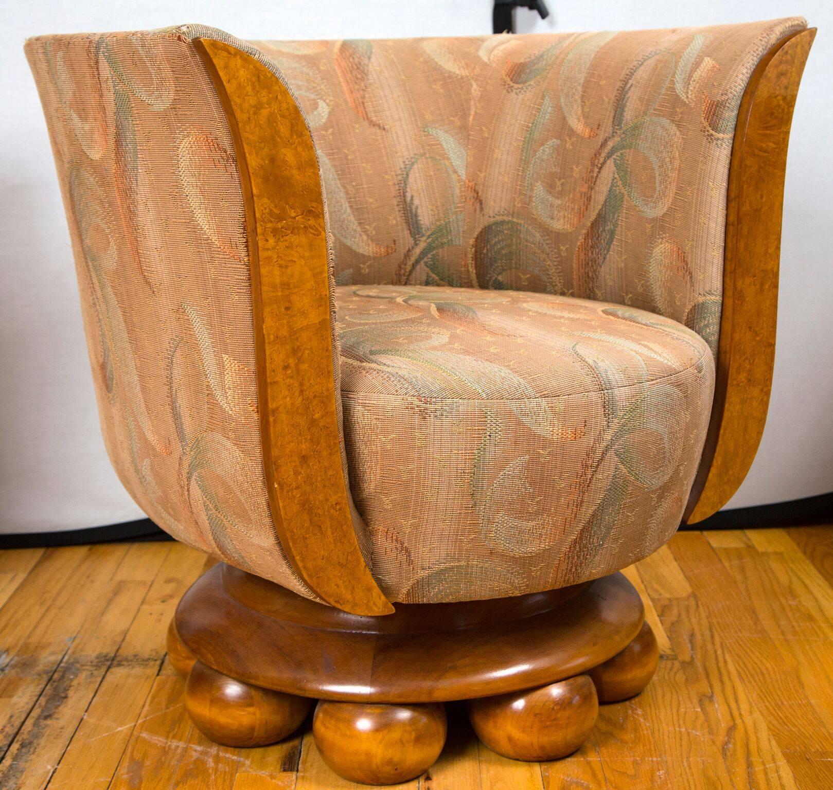 A pair of Art Deco burl wood club chairs on a circle of bun feet. The chairs were made for the Hotel Le Malandre and have the plaque attached. The upholstery is original or vintage and is worn with tears at the stress points.