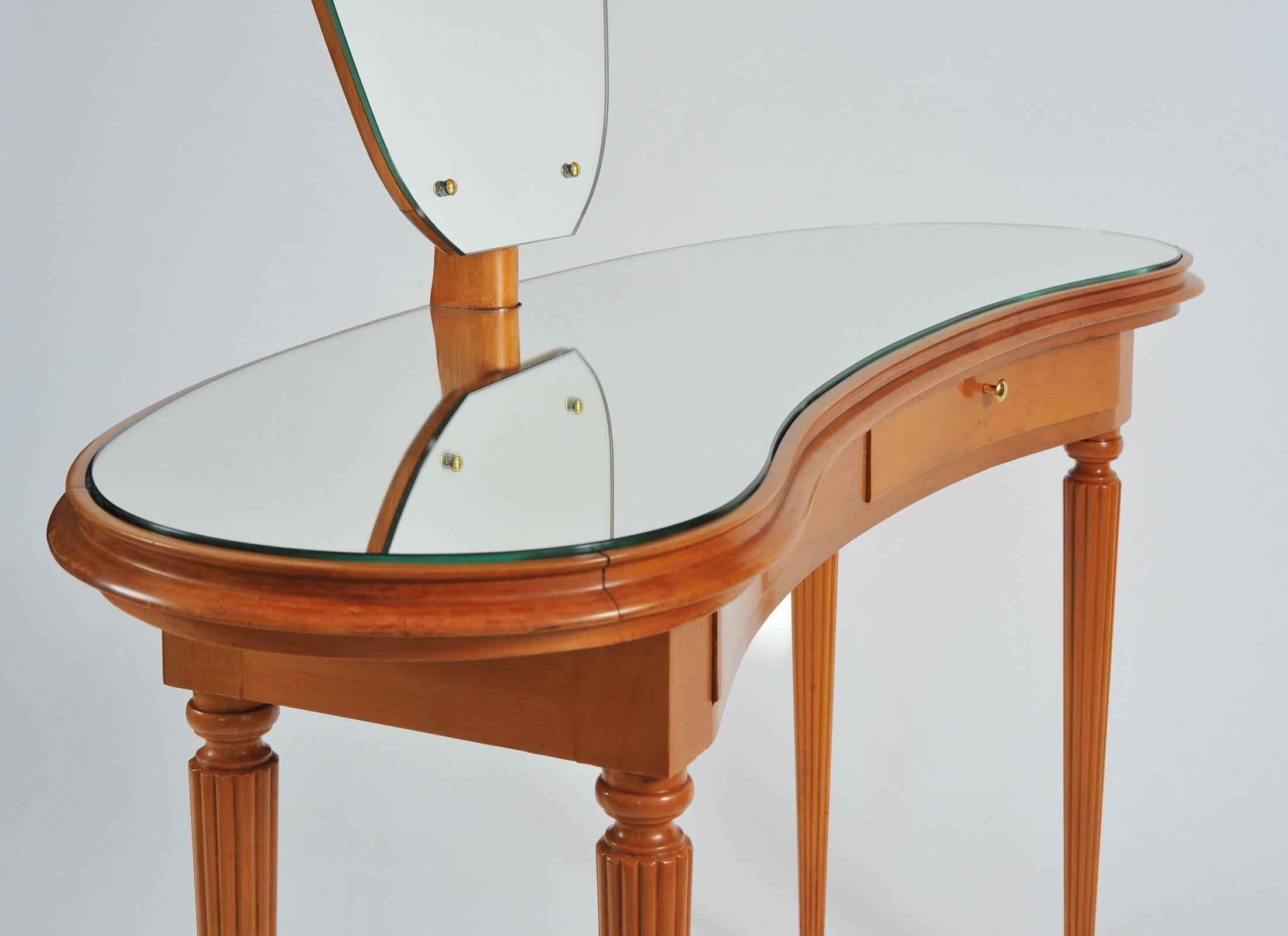 Two-drawer dressing-table in light fruit wood with large shaped mirror, on turned and fluted tapering legs.
The height given below is that of the tabletop. The height to the top of the mirror is 151cm.