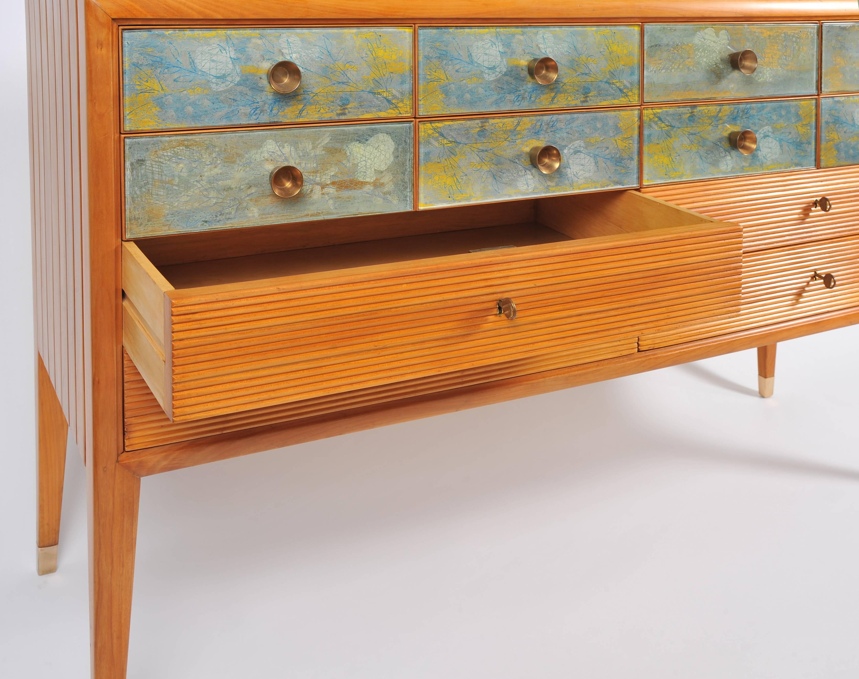 Impressive and rare 12-drawer credenza of exceptional craftsmanship and design. Attributed to Osvaldo Borsani, with drawers by Adriano Spilimbergo circa 1952.  Top eight drawers are fronted with reverse-painted abstract designs in soft blues greens