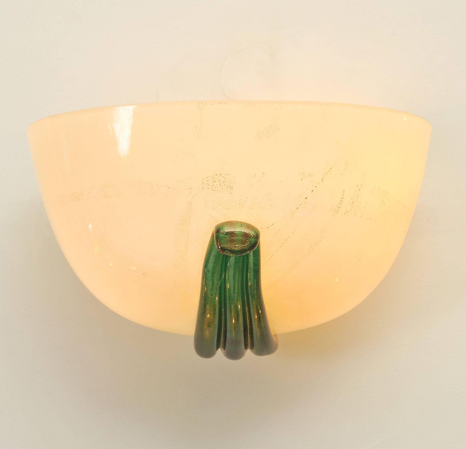 Opaque cream Murano glass semi-circular wall sconces with decorative green glass detailing.