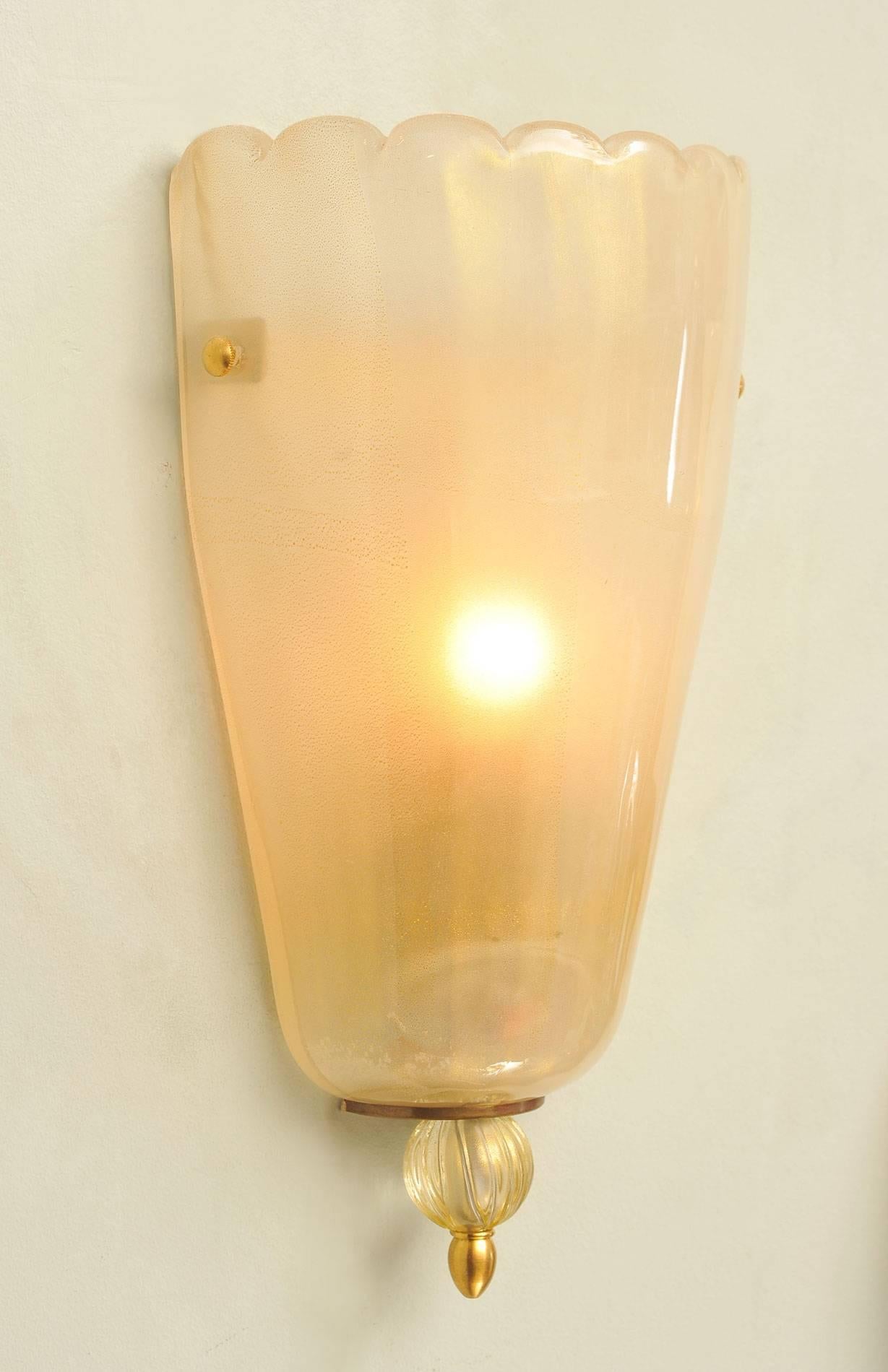 Cream aerated glass wall lights with gold flecks, softly fluted top and decorative ball finial at the base.