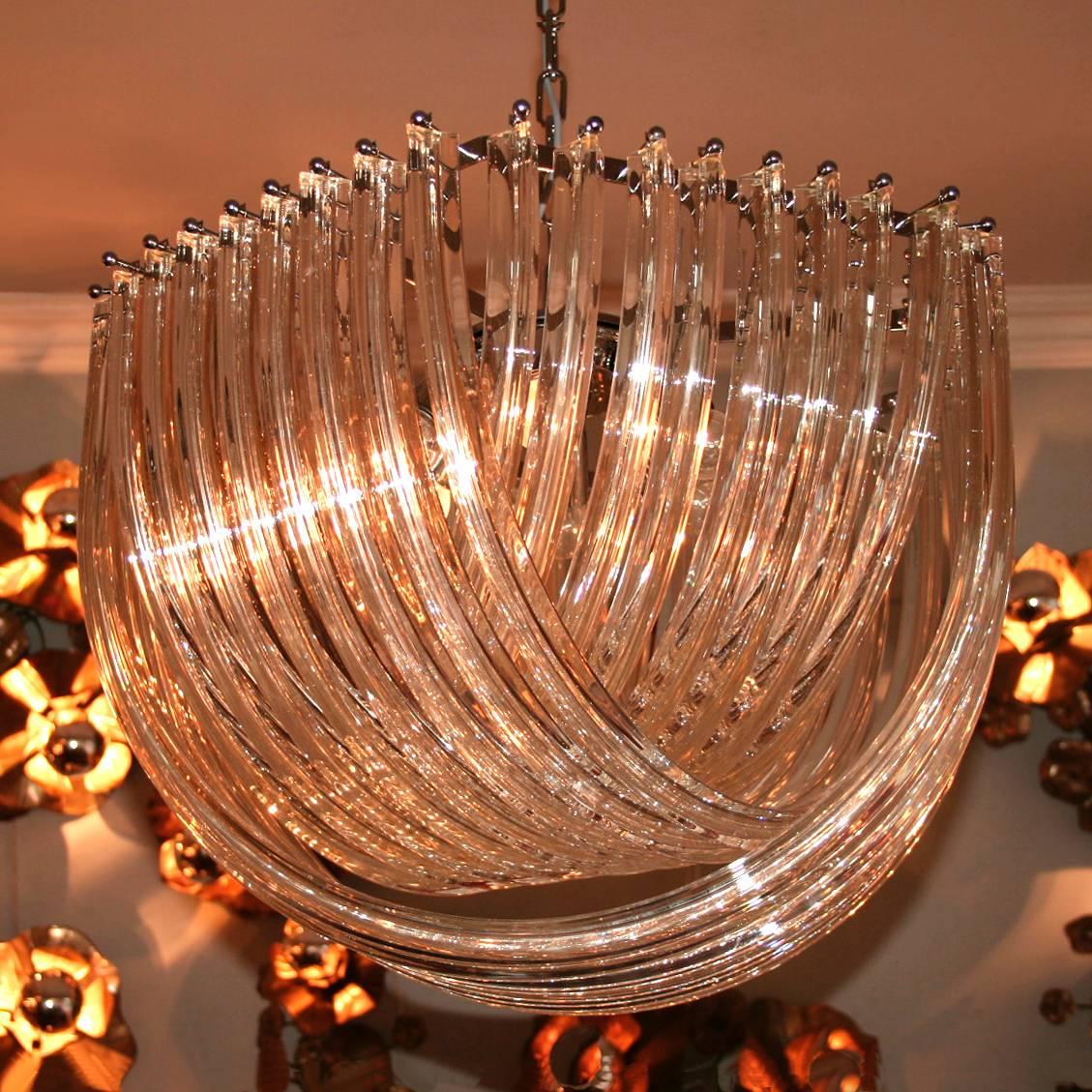 Elegant contemporary chandelier with interlaced, curved, crystal drops.
Available with a chrome or 'gold' frame and fittings.

Small: 50cm diam x 32cm drop: £3,000.
Medium: 60cm diam. x 42cm drop: £3,850.
Large: 85cm diam. x 55cm drop: £5,400.