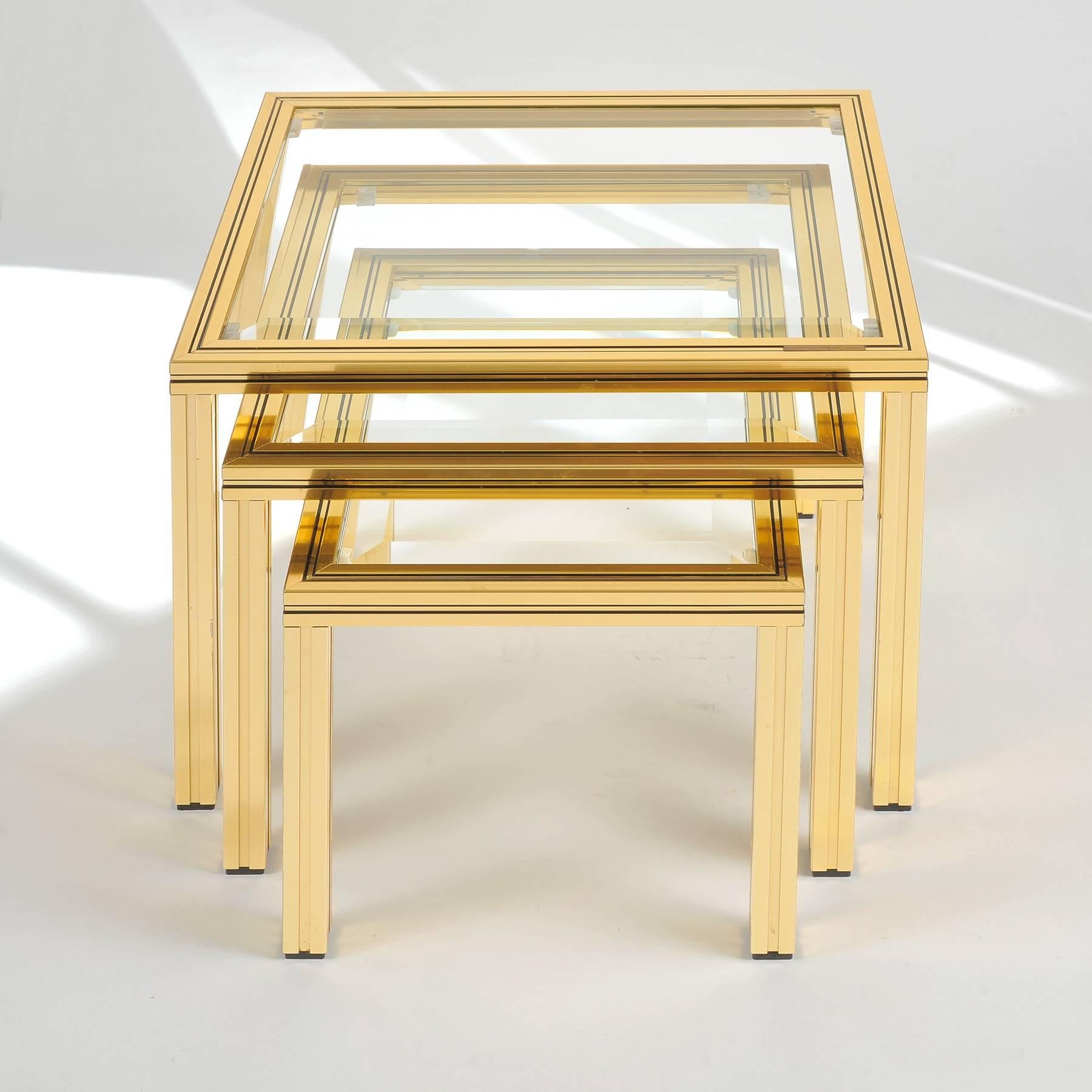 Elegant nest of three tables in brass-plated aluminium (or gilt brass) with beveled glass tops, designed by Pierre Vandel during the 1980s. Signed “PIERRE VANDEL PARIS