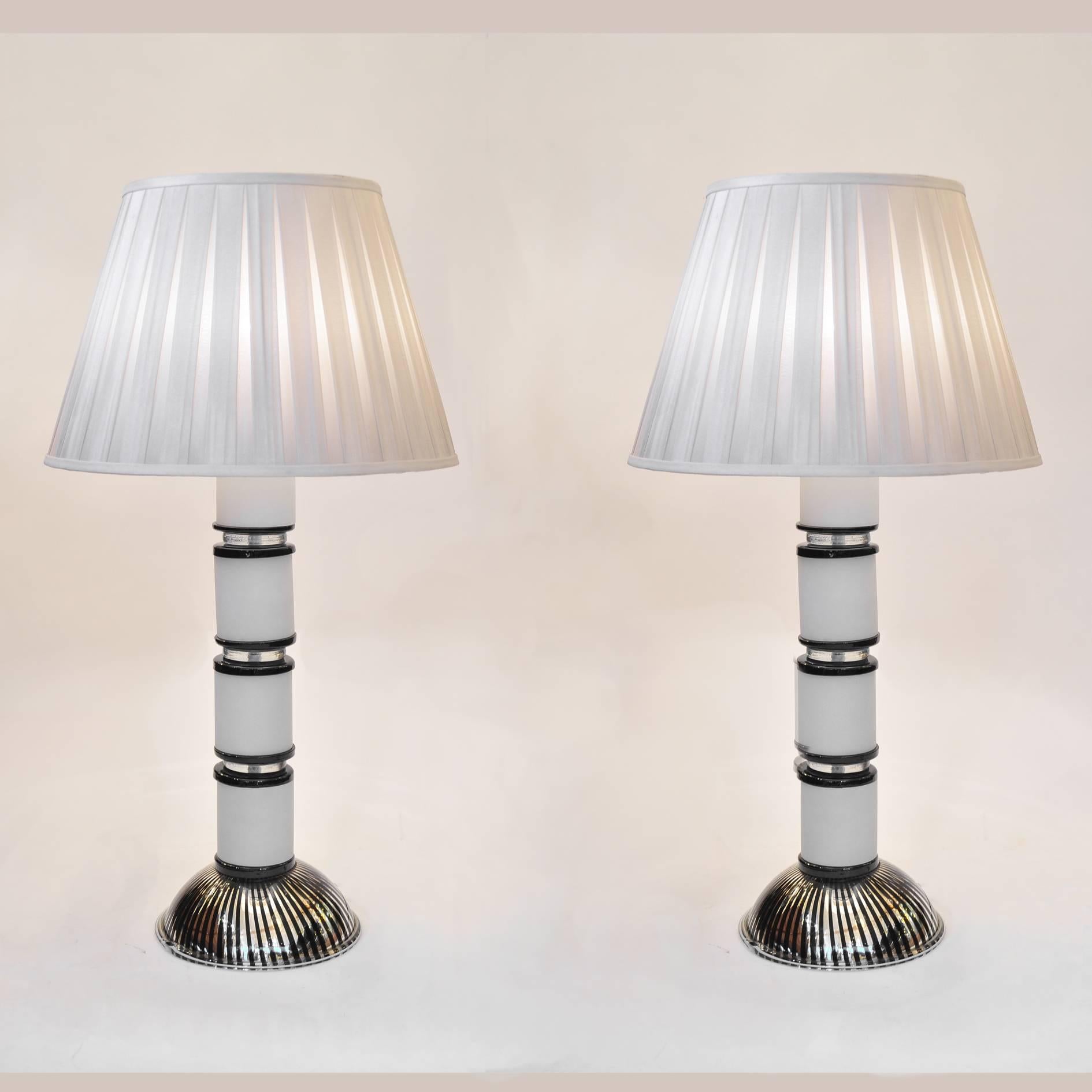 Substantial pair of Italian 1970s glass table lamps. Each piece has four white glass cylinders interspersed with black and clear glass disks sitting on a semi-circular black and silver striped base.