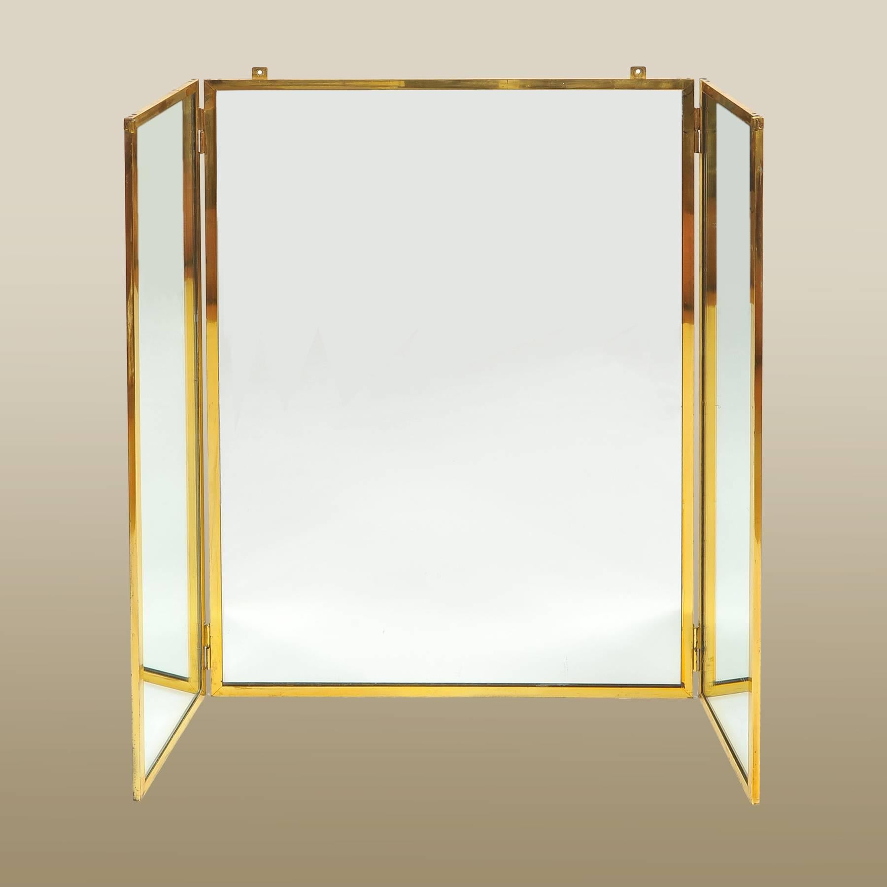 Brass triptych mirror suitable for hanging over a dressing table, felt-lined back.