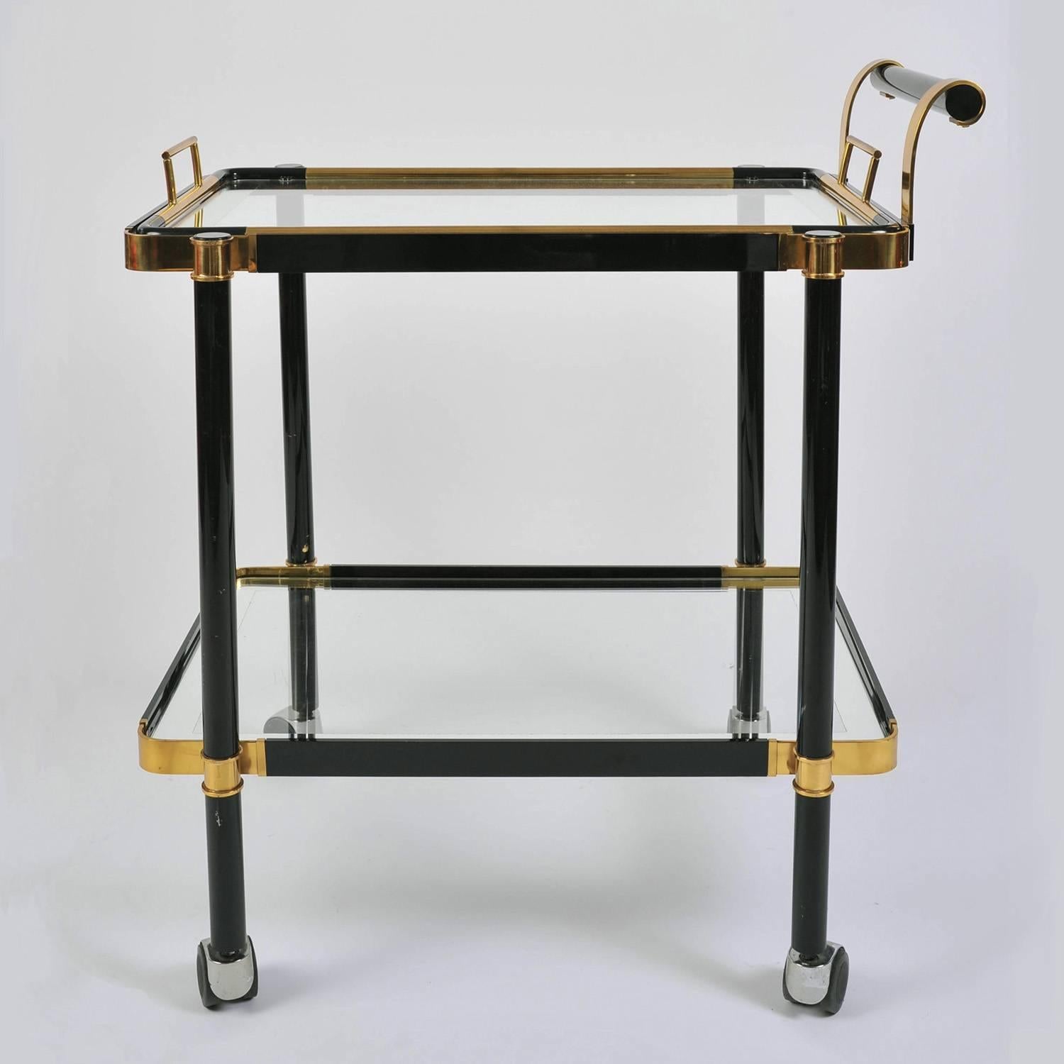 Well-proportioned two-tier black metal and brass drinks trolley. Each glass shelf is framed with mirrored glass. The top shelf doubles as a detachable tray for handing around the drinks. Caster wheels make it easy to manoeuvre.