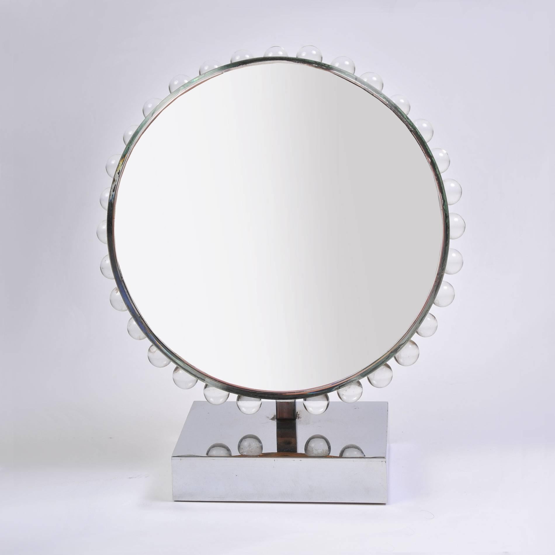 Circular mirror framed by glass balls. Sits on square chrome base.