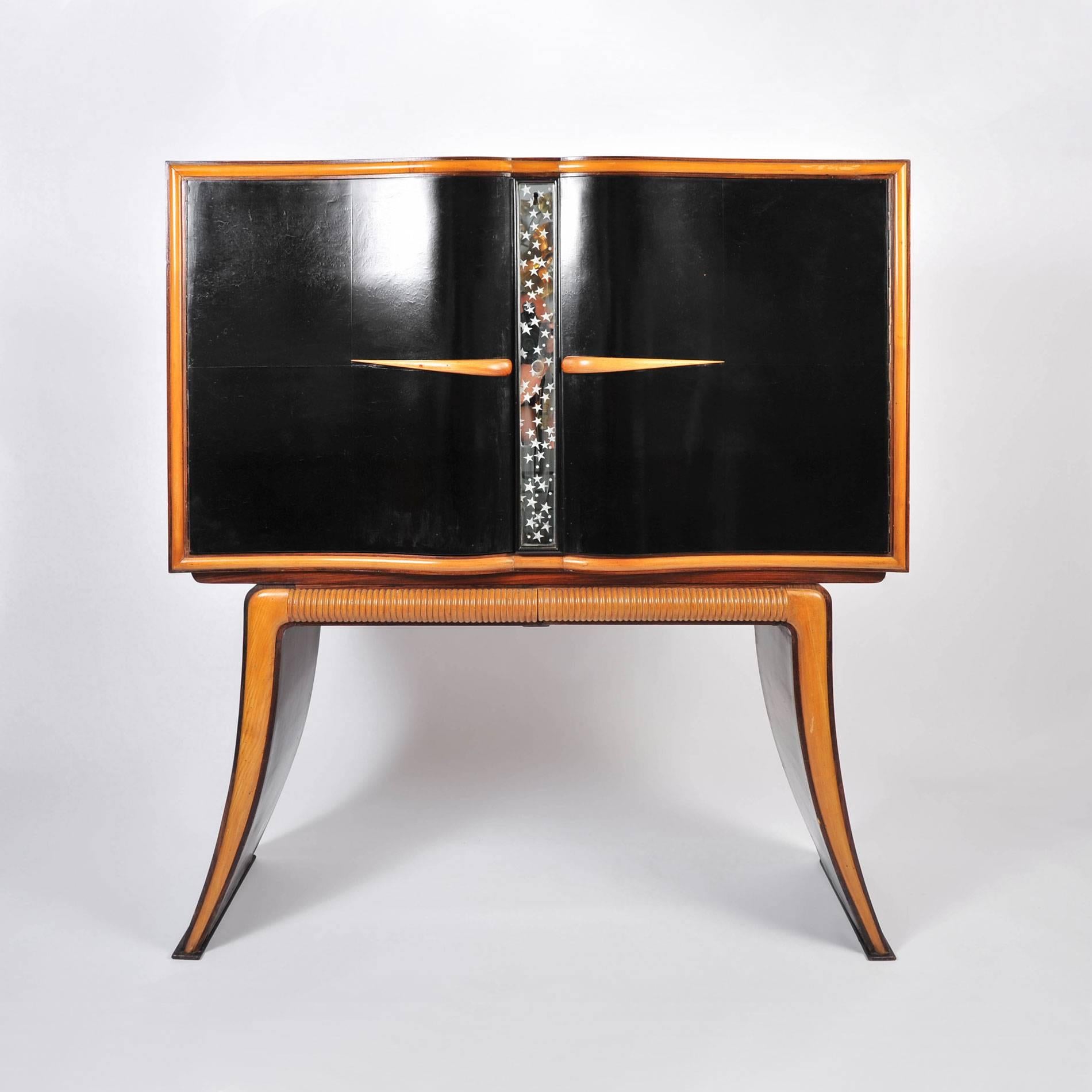 Spectacular drinks cabinet with dark mahogany doors opening to a dazzling world of night stars and dancing ladies entwined in nature. Exterior ebonised fruitwood doors are detailed in veneered mahogany and separated by a starry mirrored panel.