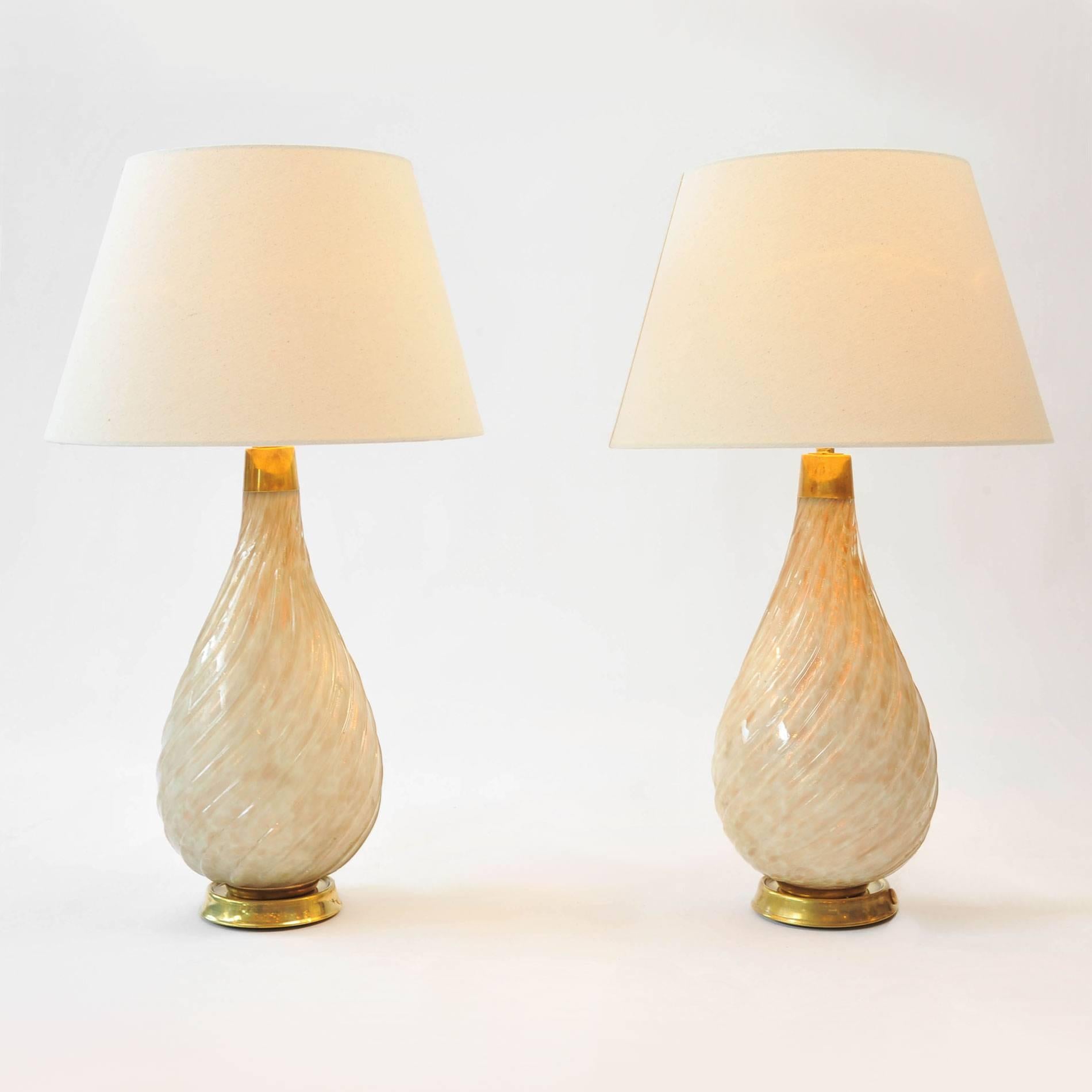 Contemporary table lamps of iridescent fluted glass on circular brass bases.

The dimensions below are those of the each lamp only. The shades are 8.75 inches high.