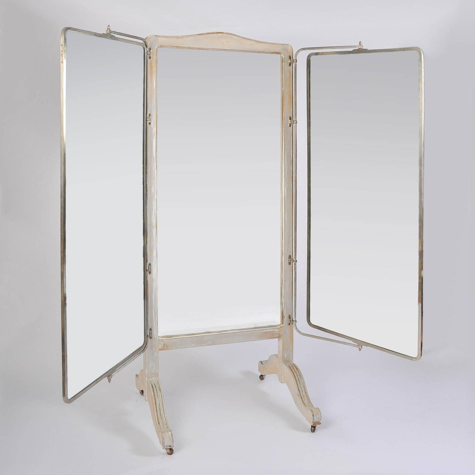 Impressive very tall free-standing triple mirror to ensure a 190% view. The curved wooden central fame and base are painted subtle grey - and generous side mirrors are supported by chrome frames ingeniously designed so that they move in all