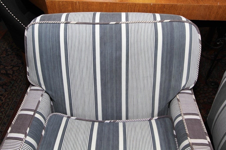 Very comfortable pair of Mid-Century chairs reupholstered in vintage varying blue stripe French stripe cotton. Down wrapped cushions and wonderful details.
