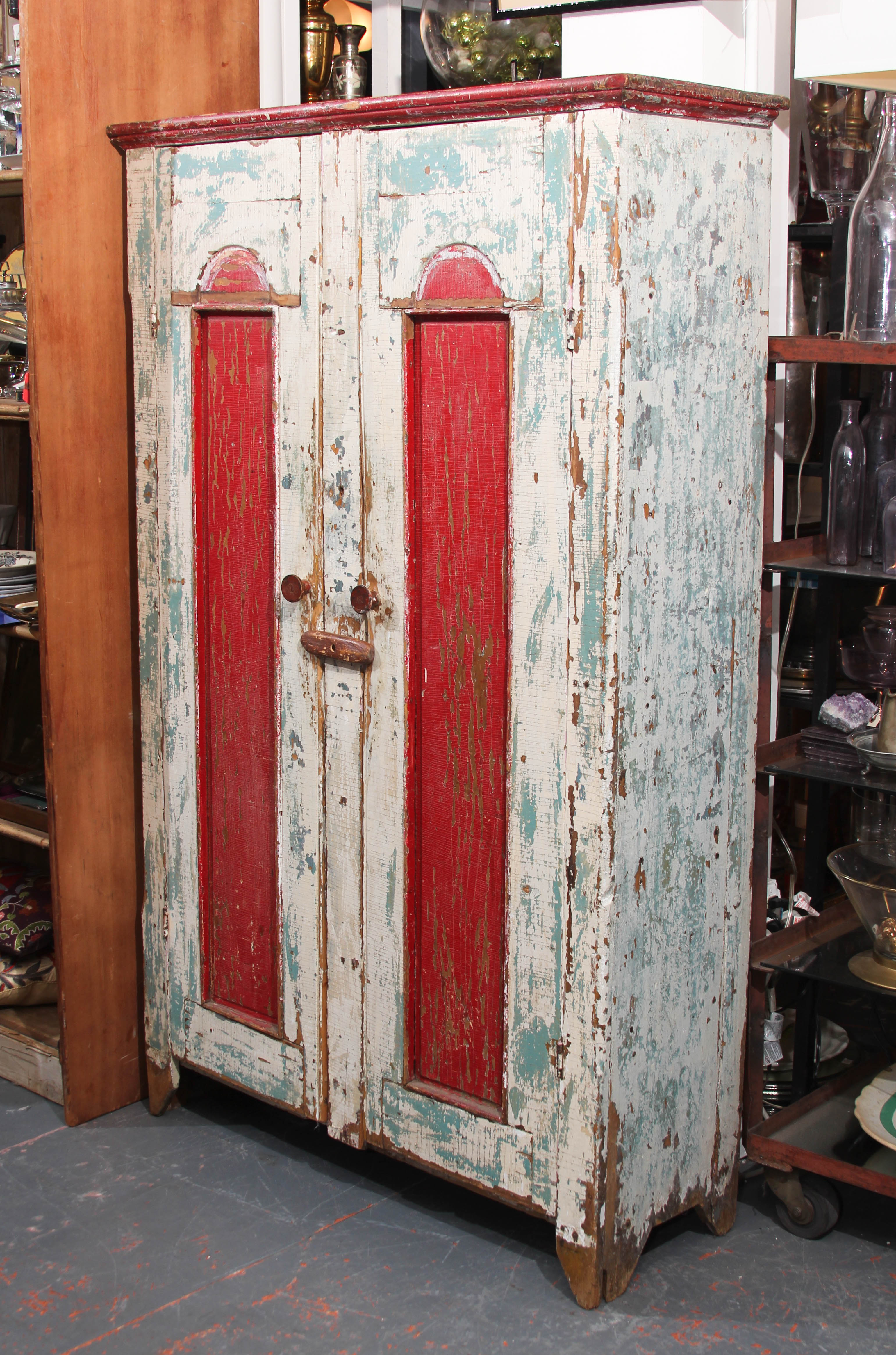 Antique cabinet from American Midwest in great old paint. Shelves inside are perfect for storing clothing , kitchen items or anything else you want close at hand but hidden from view.