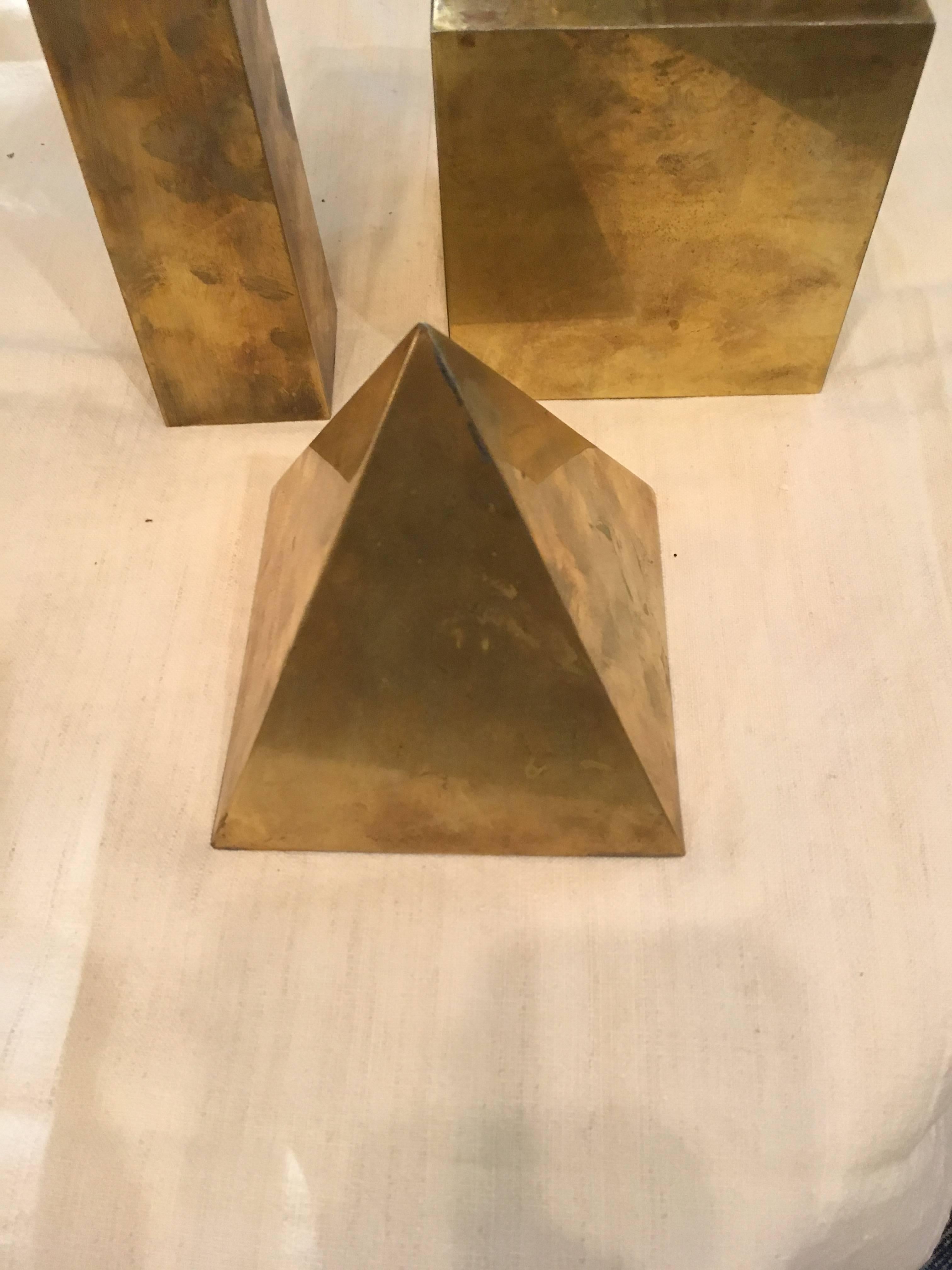 Set of three brass decorative forms. Great as a collection or string enough each in its own 
Measures: Obelisk is 14.5 tall x 2.5 x 2.5
Cube is 5.5 x 5.5 x 5.5
Pyramid is 5.25 x 5.25 x 6.