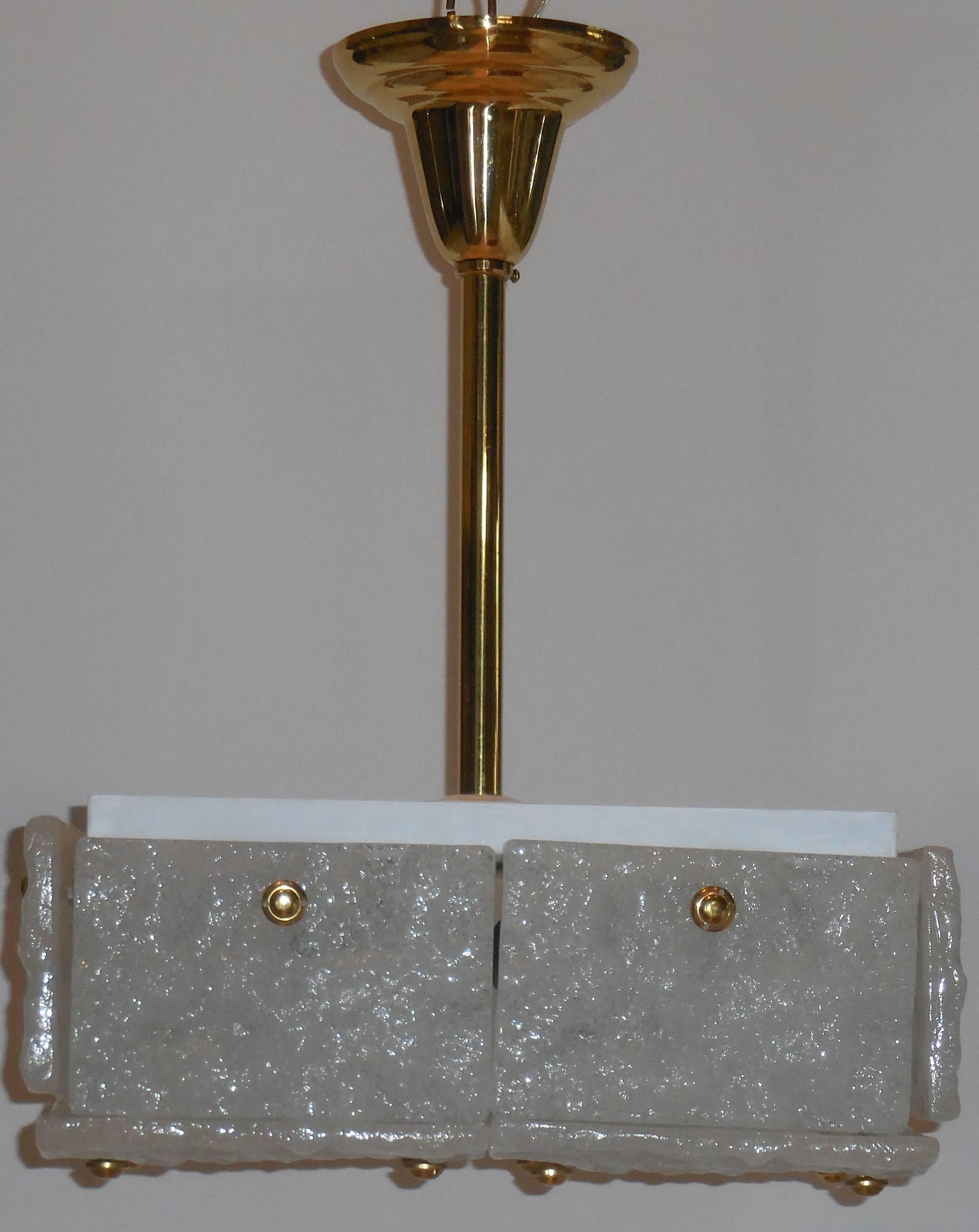 Bellissimo lampadario quadrato quebista, composto da 12 lastre di vetro smerigliato bianco,
Fissato al telaio in acciaio tramite una ferramenta in ottone, il gambo e il baldacchino sono in ottone.
Elettrificato con 4 luci da 60 watt.
Misure: