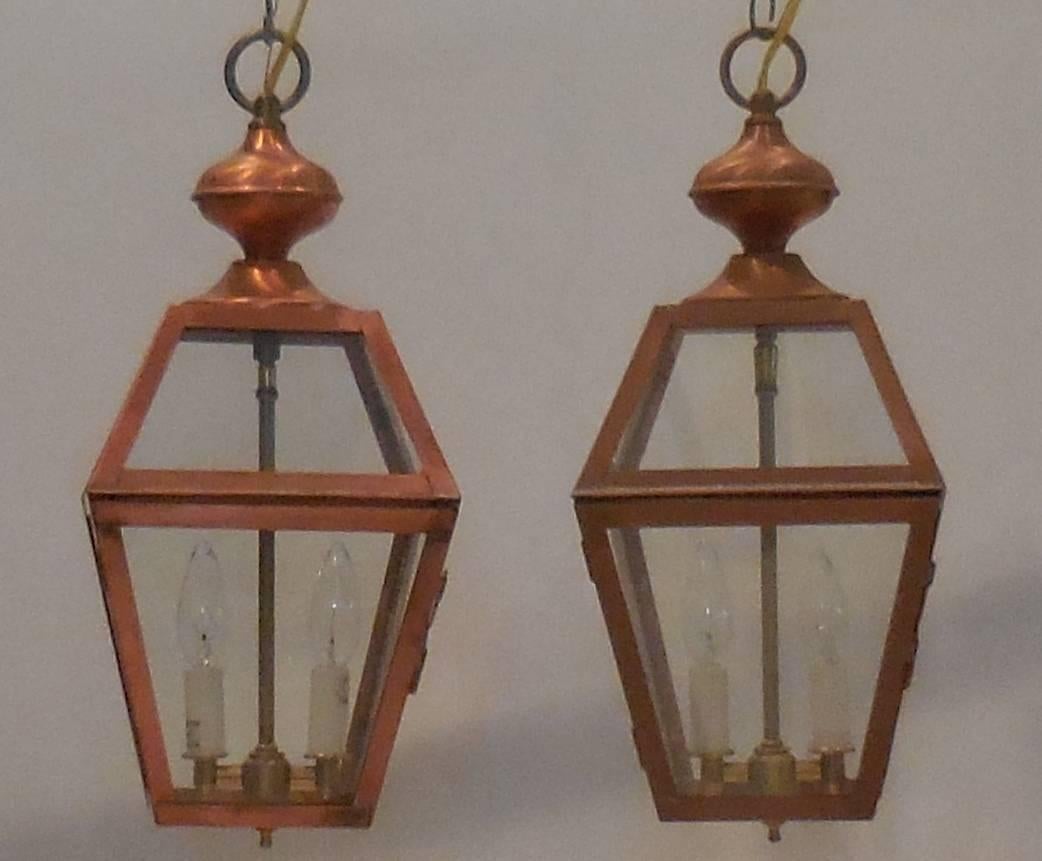 Elegant pair of hanging lantern made of copper with brass cluster of two
60/watt lights.
Electrified up to US code UL approved. Measures: 9