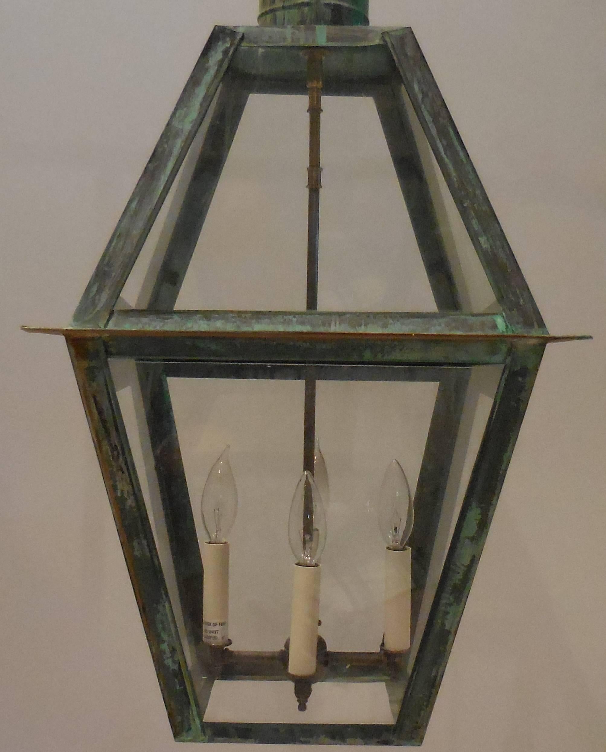 Large architectural lantern made of copper with great looking weathered patina.
Brass cluster of four lights 60/watt each.
UL approve and up to US code.
Copper canopy and chain included.

One more is available. Measures: 15.5 x 15.5 x 36