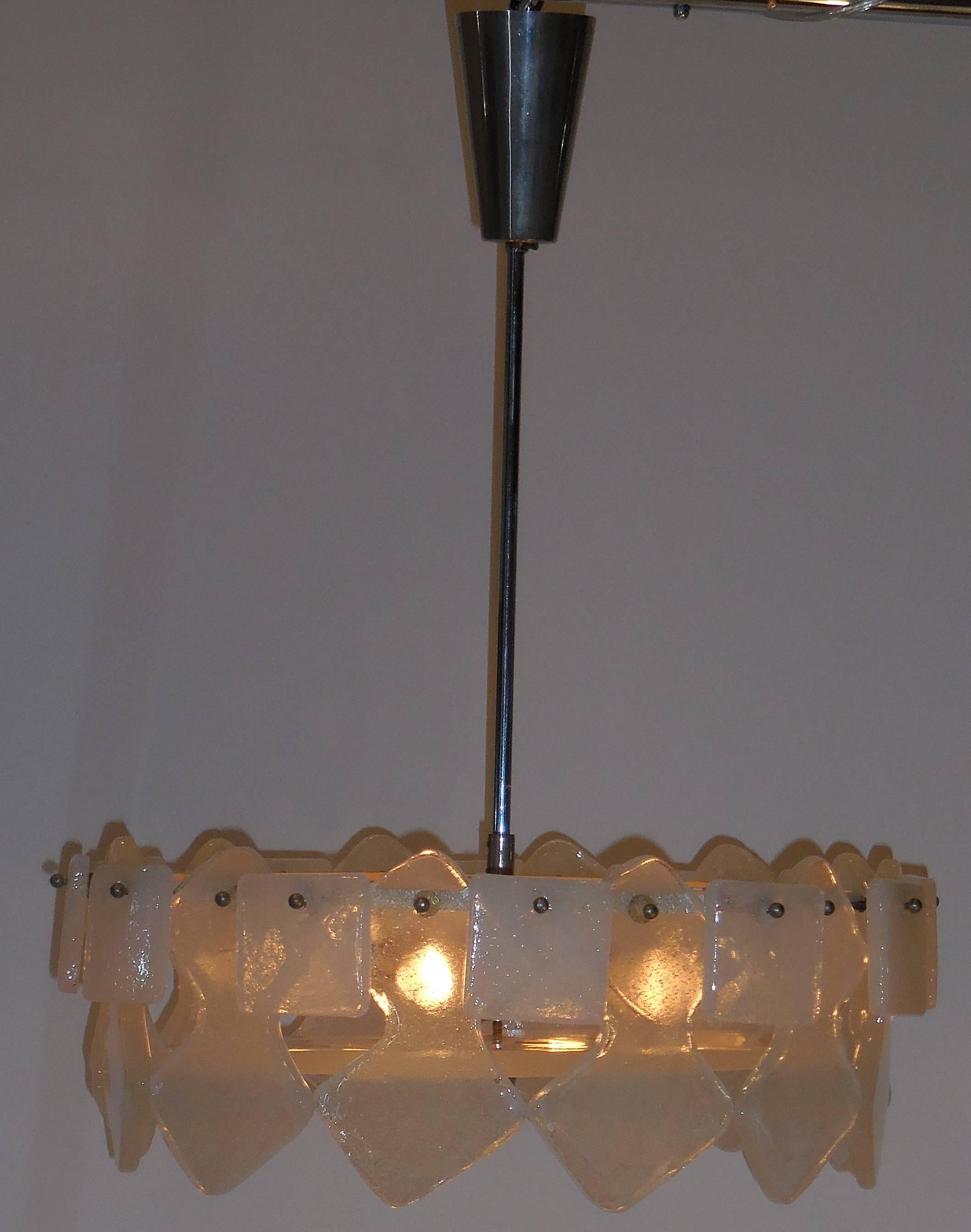 Beautiful glass chandelier made of two kinds of lightly frosted glass prisms.
Square prisms and arrow shape praises all put together to make this fantastic 
light.
One round glass piece is mounted on the bottom.
Metal frame and crome