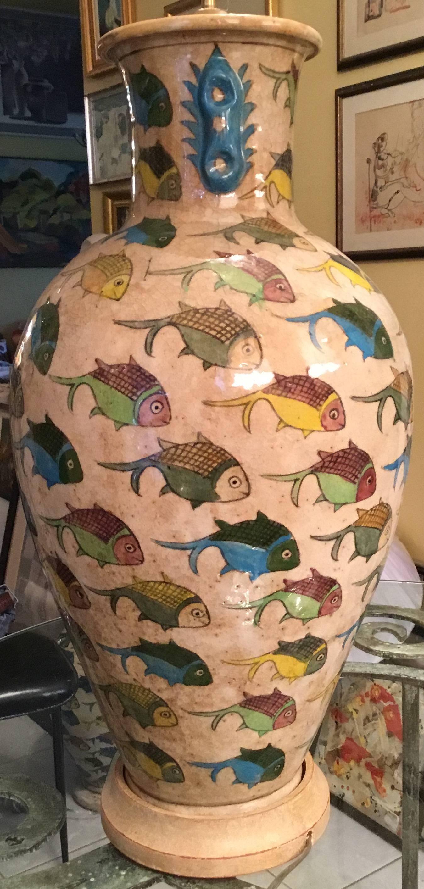 Beautiful Persian ceramic vase made to a table lamp, hand-painted and glazed 
with multi motifs of colorful fish, on a cream color background.
Mounted on wood base, newly electrified and ready to light. 
Shade is not included.
Size: from the