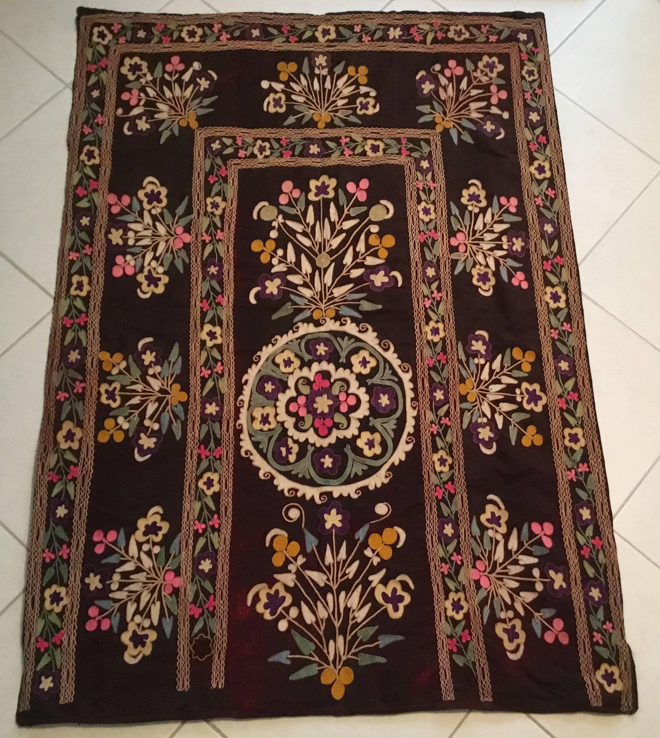 Beautiful Suzani textile made of exceptional hand embroidery of vine and flowers on a muted wine color velvet background.
The velvet background partially oxidized due to the age, but still strong and firm. The Suzani also has full cotton