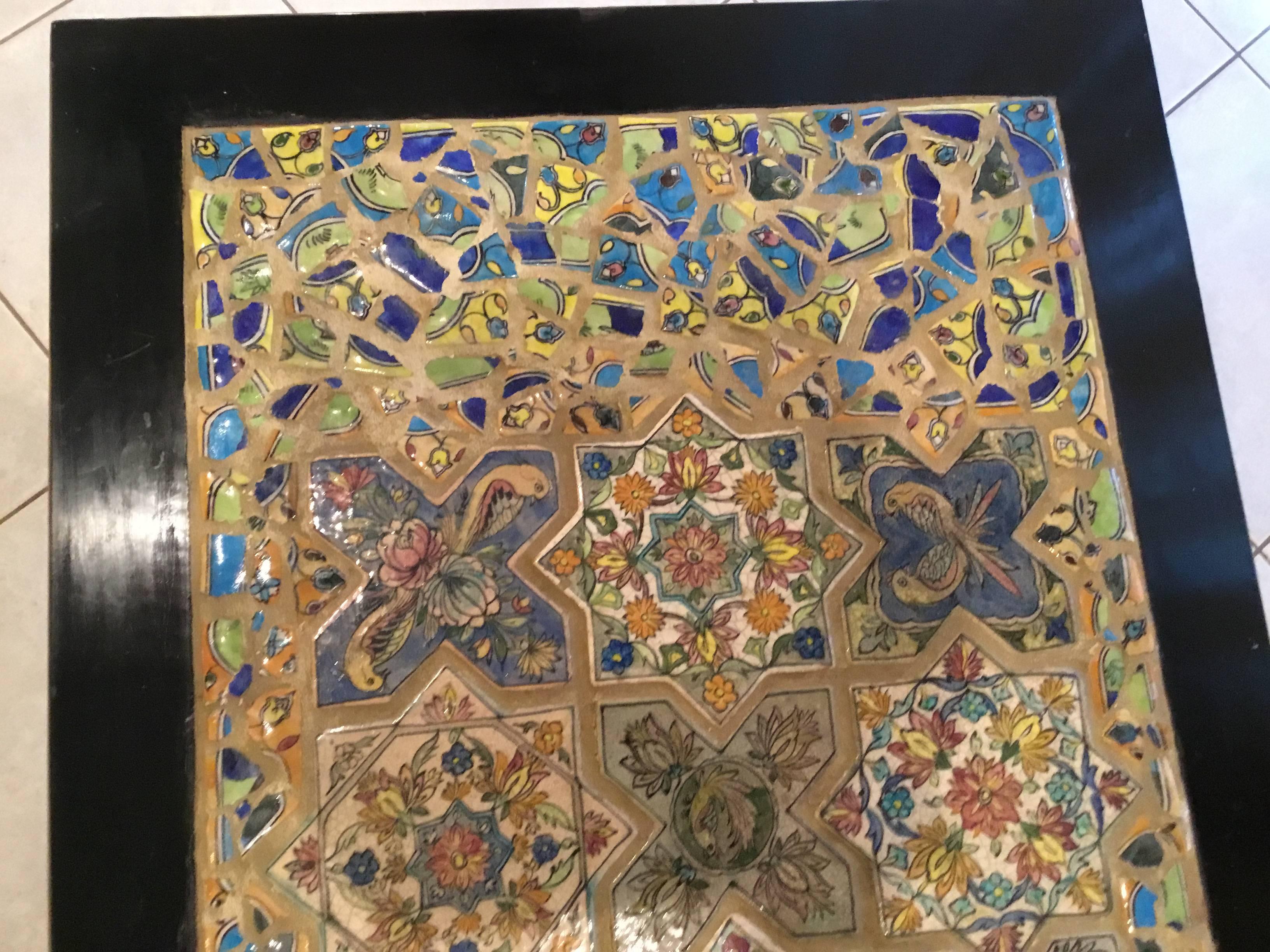 Fantastic one of a kind coffee table made of old Chinese wood coffee table imbedded with beautiful antique Persian ceramic tiles with flowers vines and birds motifs. All surrounded with colorful Persian tile mosaic.
Water repellent top.

