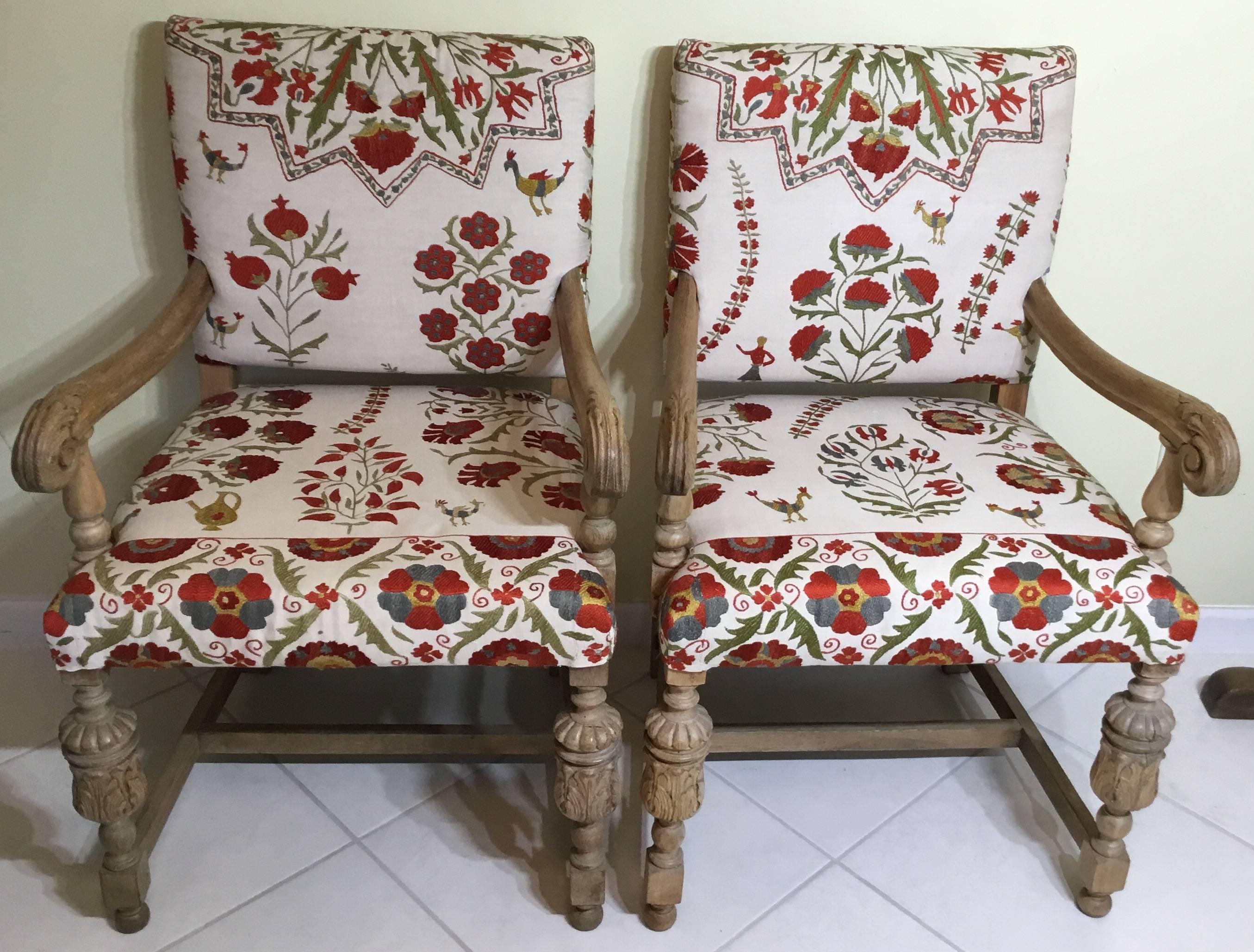 Exceptional pair of antique light wood hand-carved armchier, all covered with 
Beautiful Suzani textile, hand embroidery silk on cream color background.
Floral, vines and birds motifs.
One of a kind will look great in any room, a conversation