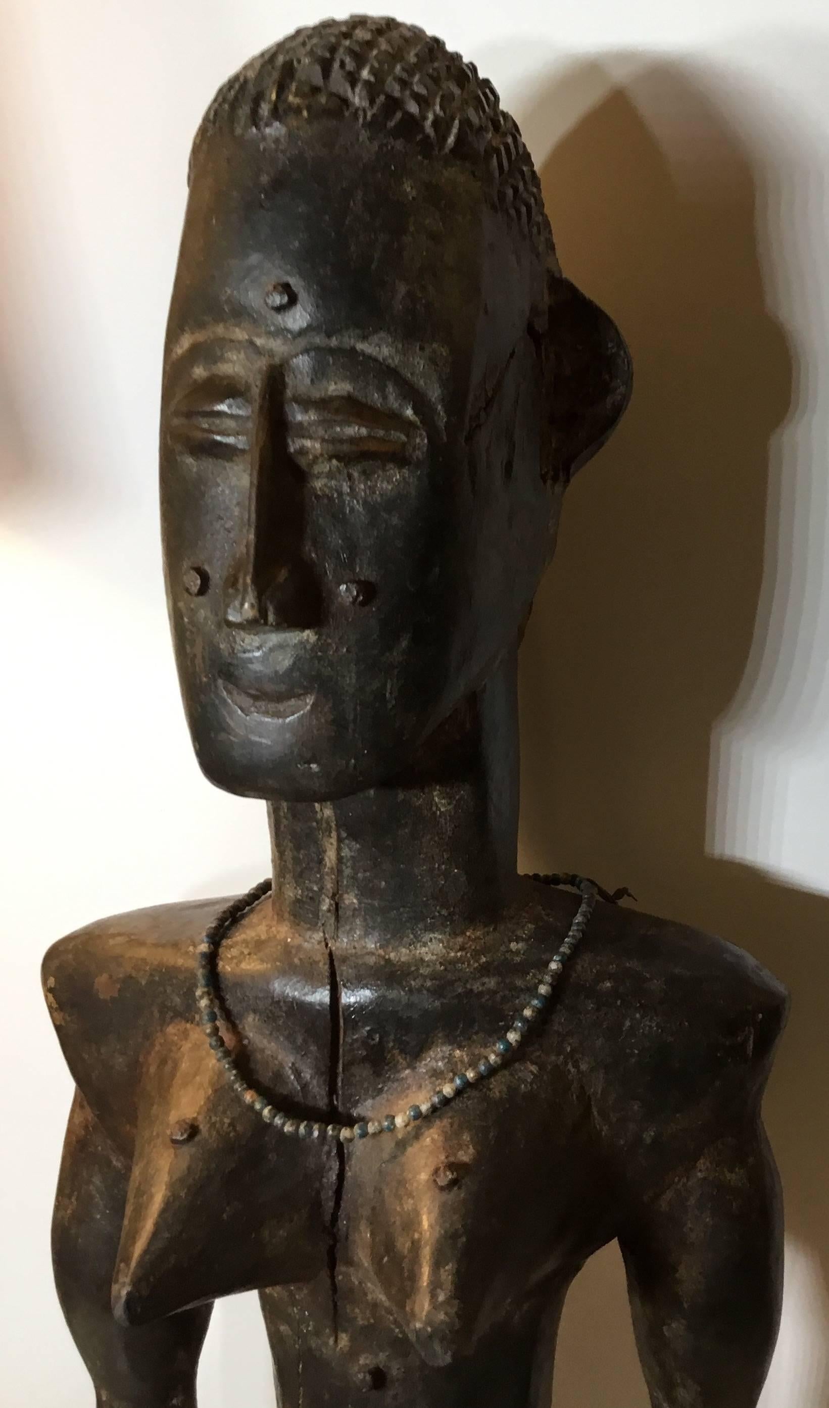  male figure made of carved wood depicting handsome warrior,
Elaborate details of the face, hair and body, with original beaded jewelry on the
Neck and hand. Split in the front due to age, otherwise very good condition.
Professionally mounted on a