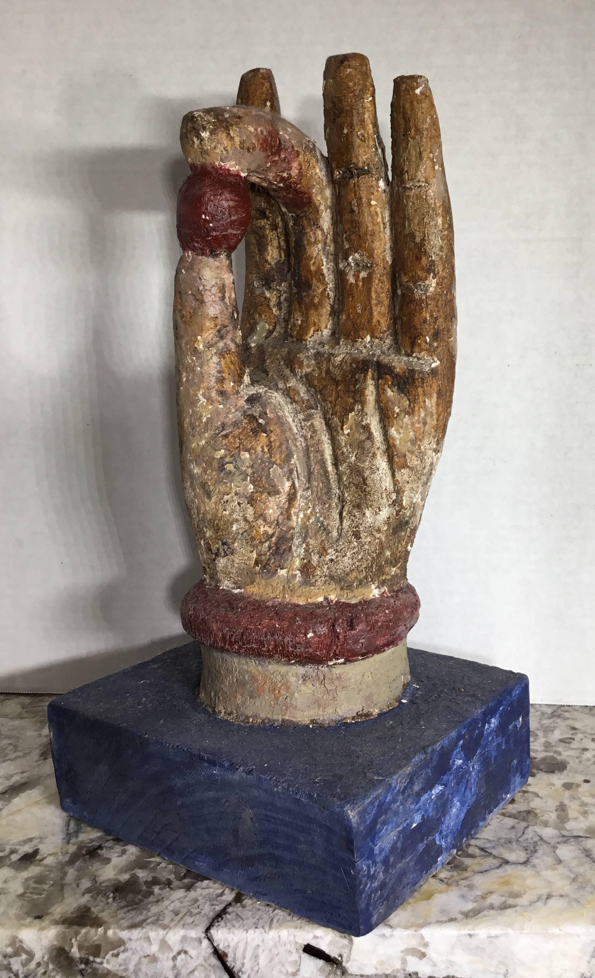 Elegant carving made of wood and hand painted of Buddha hand. This decorative piece went through time and the elements, and missing some paint and gesso and still looking interesting and inviting.