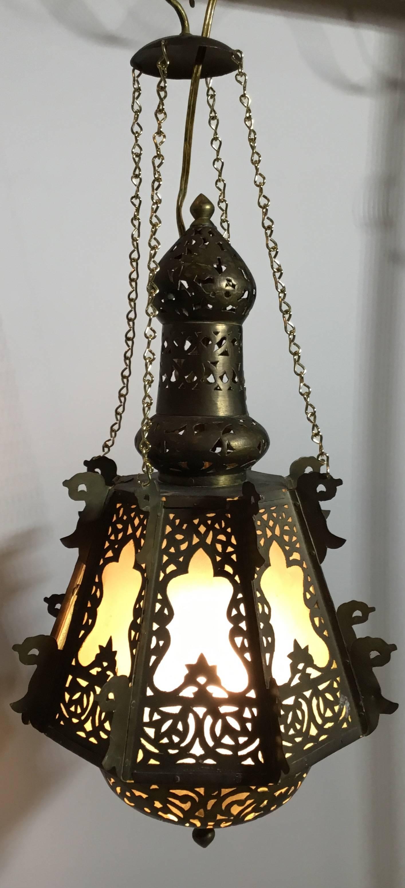 Elegant hanging lantern made of brass handcrafted by skilled artisan, 160 watt light, in working order, frosted glass very decorative.
Lantern height only without the chain 17”.