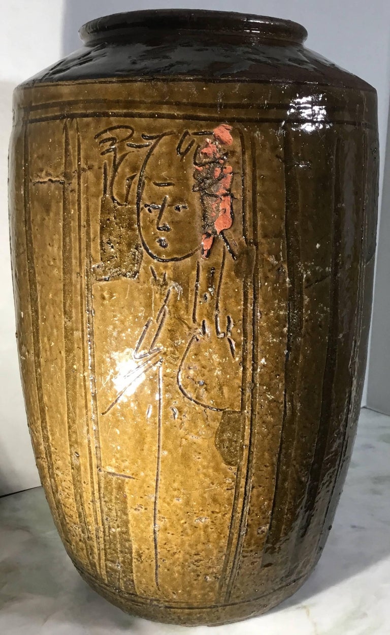 Elegant Chinese stoneware vase with muster greenish color artistically press
and painted of faces that look very decorative and interesting.
Vessel like this used as storage for fruit spices wine and water.