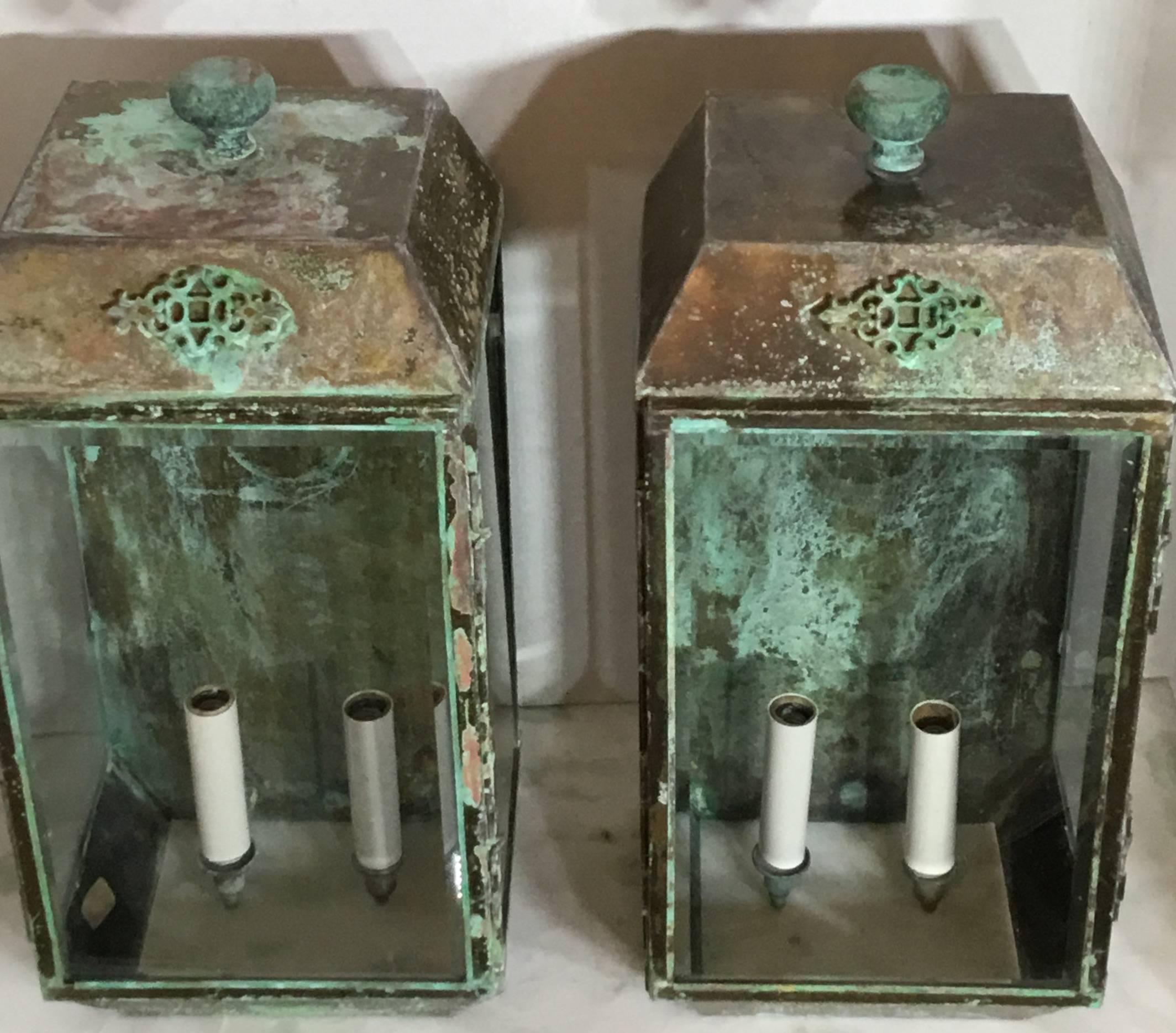 Pair of architectural wall lanterns made of brass with the original beveled glass in the front, great looking weather patina, wired with two 60/watt light each and ready to use.