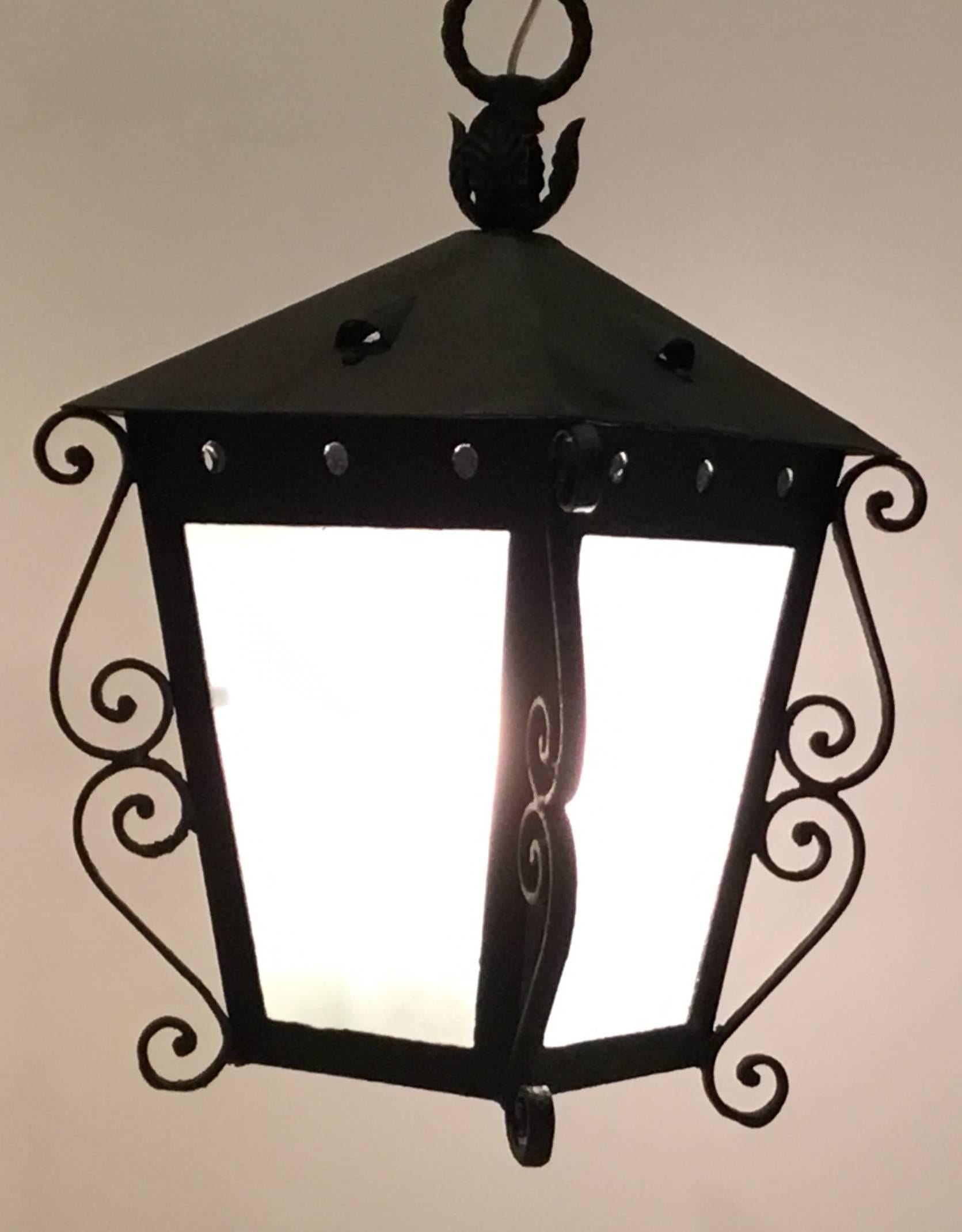 Vintage Hanging lantern made of forged iron in the Architectural style of palm beach Mizner,
Milk color glass ,newly electrified with two 60/watt lights ,ready to hang and use.