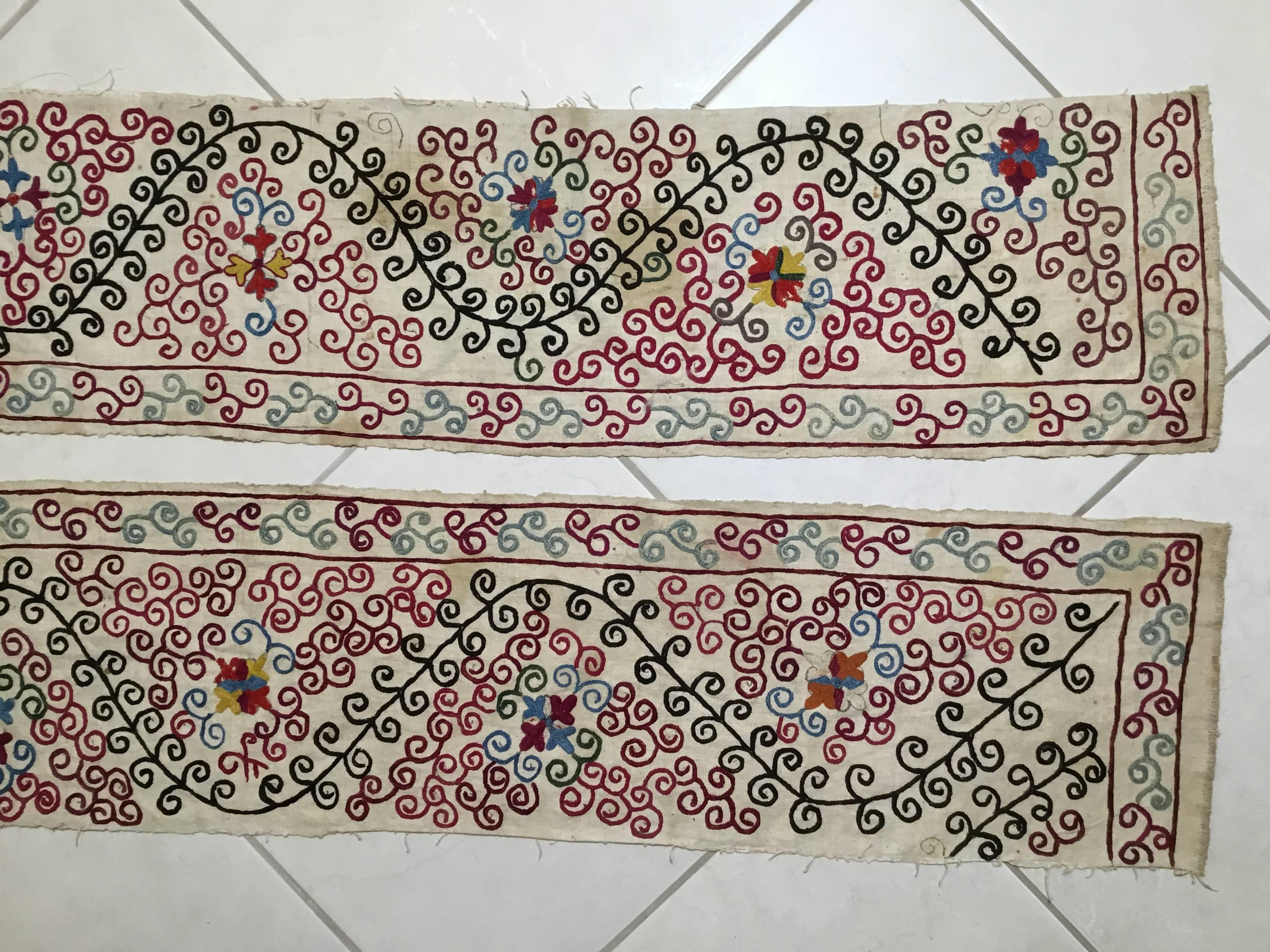 Pair of antique Suzani fragment made of hand embroidery intricate scrolling vine motif on a handwoven cotton background.
This piece has some spots and fading areas that happen during time, but still has a good structural quality so you can make