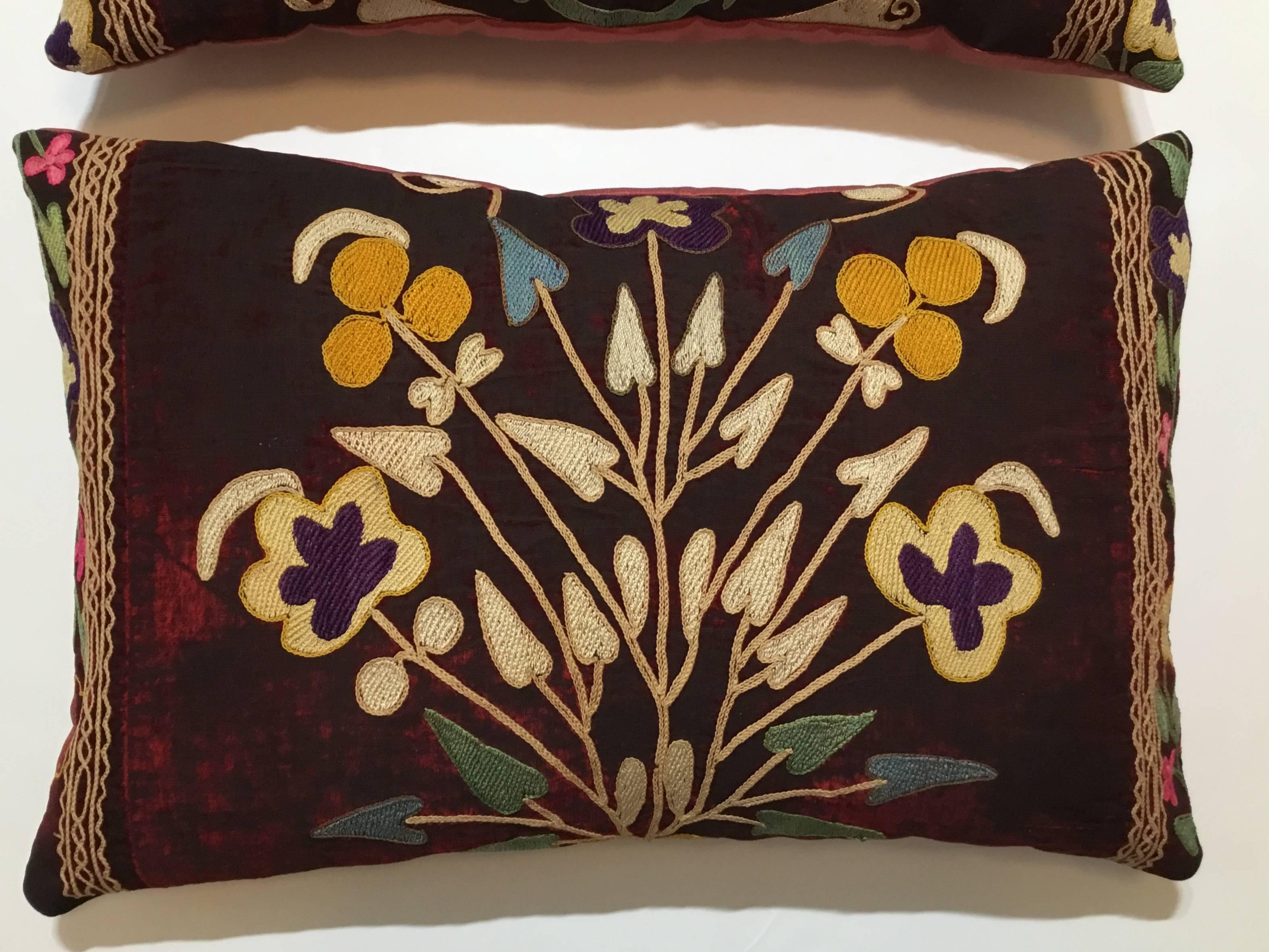 Exceptional pair of pillows made of antique hand embroidery Suzani fragment, beautiful colors of vine and floral motifs all embroidered on a antique oxidized wine color velvet. Quality backing, frash inserts. Great pair for room decoration.
 