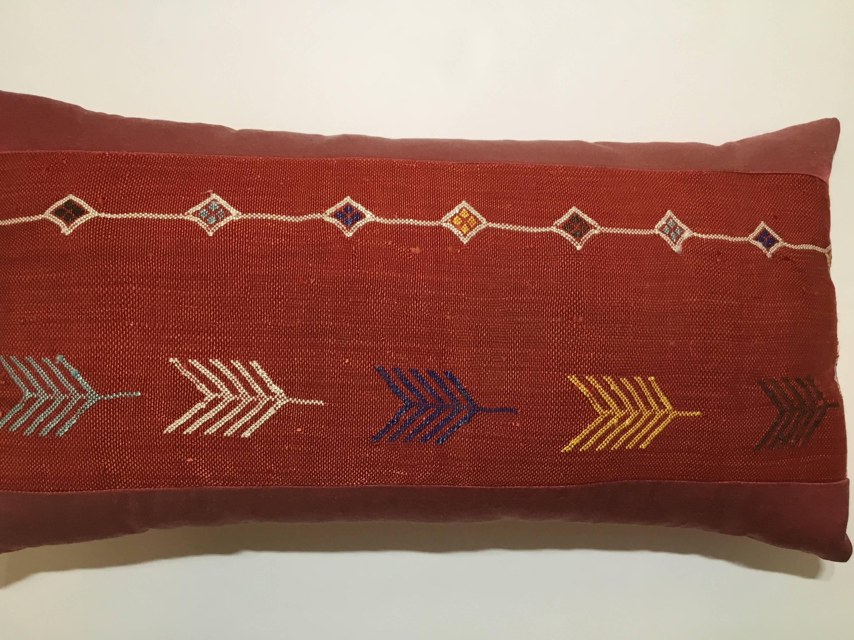 Beautiful pillow made of handwoven flat-weave textile, with colorful geometric motifs on a red background silk sides trimming silk backing frash insert.

 
