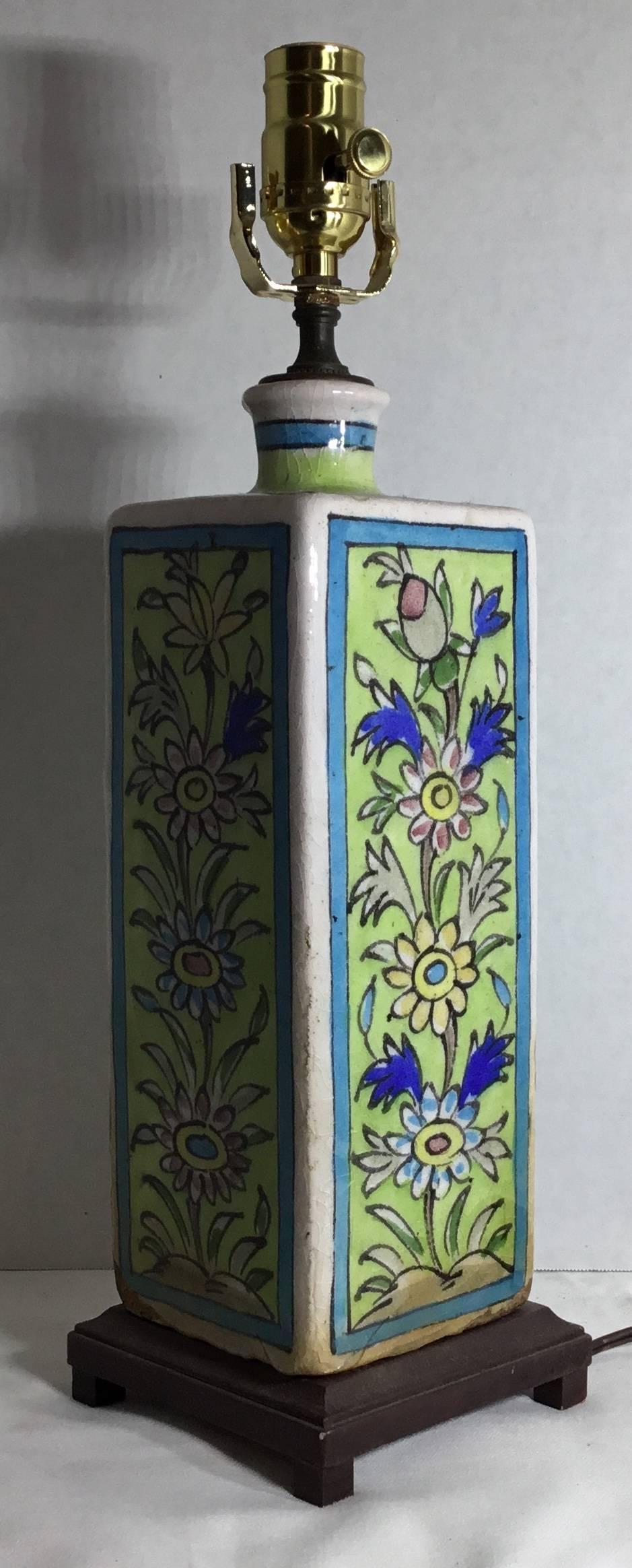 Beautiful table lamp in square shape made of ceramic, hand-painted and glazed with colorful flowers and vine motifs mounted on decorative wood base, electrified with one light ready to use. The ceramic has some missing top layers due to process of