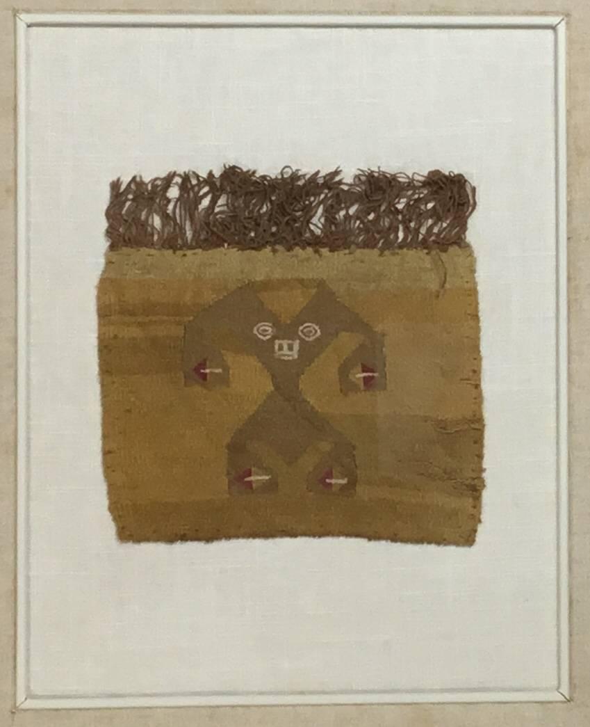 Museum quality handwoven textile fragment, featuring human or Martian motif professionally mounted on a acid free matte in very decorative wood shadow box. The textile dated from late horizon -early colonial AD 1476 to 1600 Chimu, slit