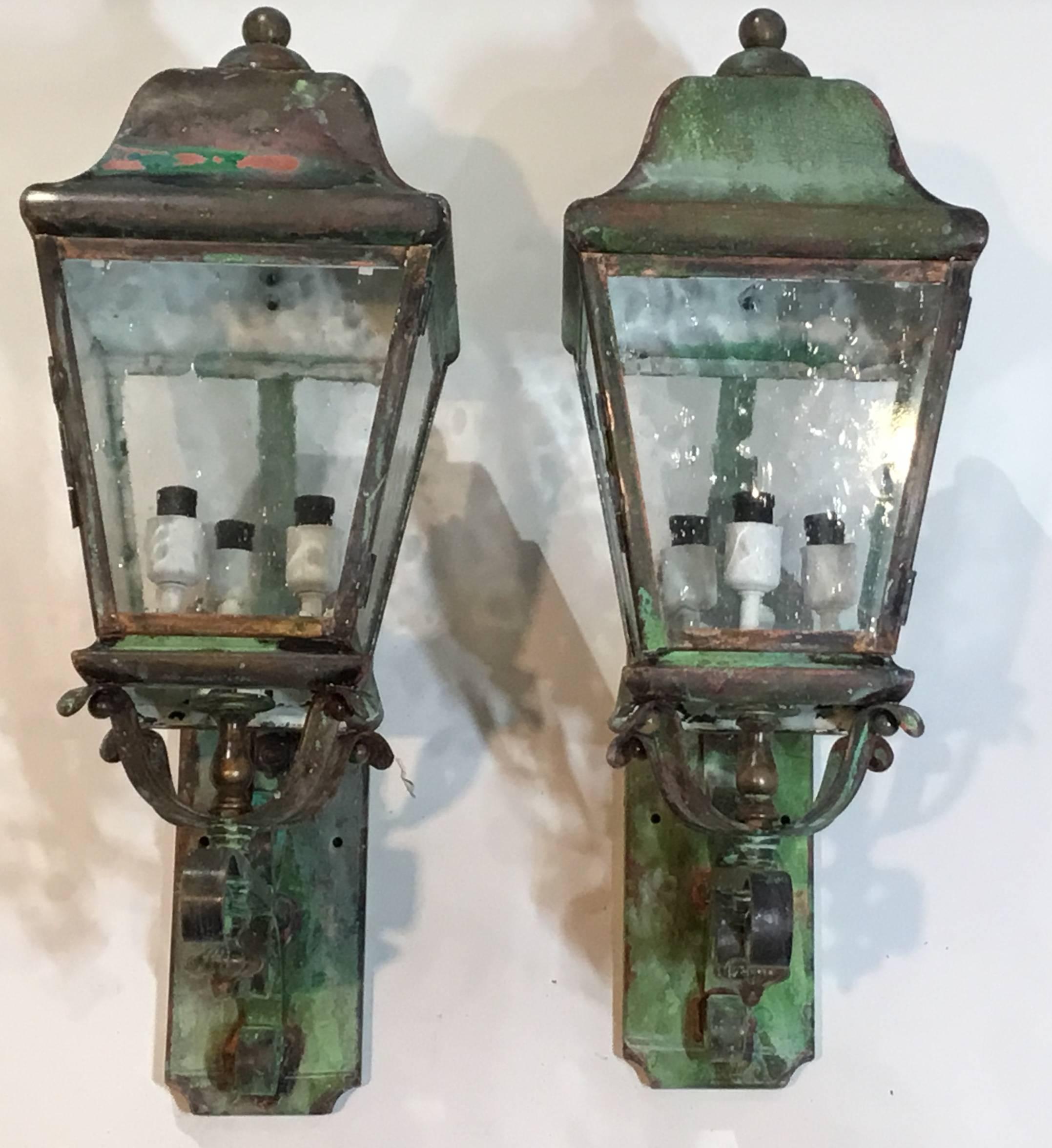 Elegant pair of vintage wall-mounted lantern made of brass and, with three 60/watt light on each,
Great looking patina very impressive in any front door or decorative indoor space.
One of the arm was slightly bent in order to have the lantern