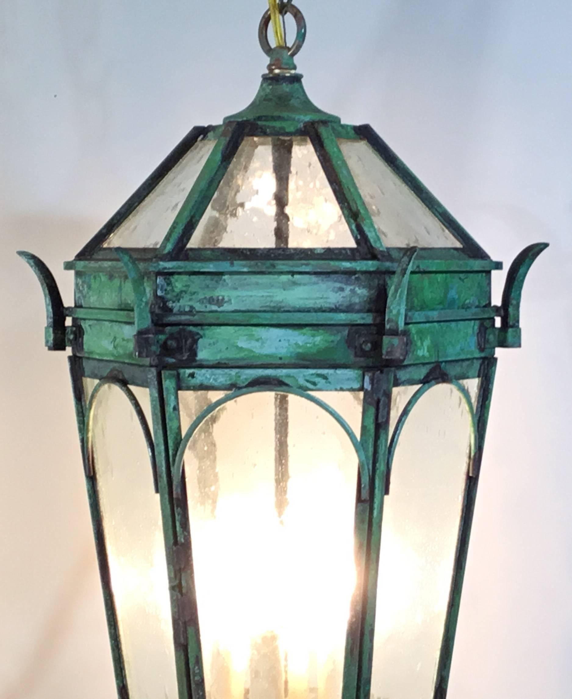 Architectural Hanging lantern artistically made of solid brass ,beautifull patina , withs seeded glass  electrified with four 60/watt lights  ready to use. Copper canopy included.
